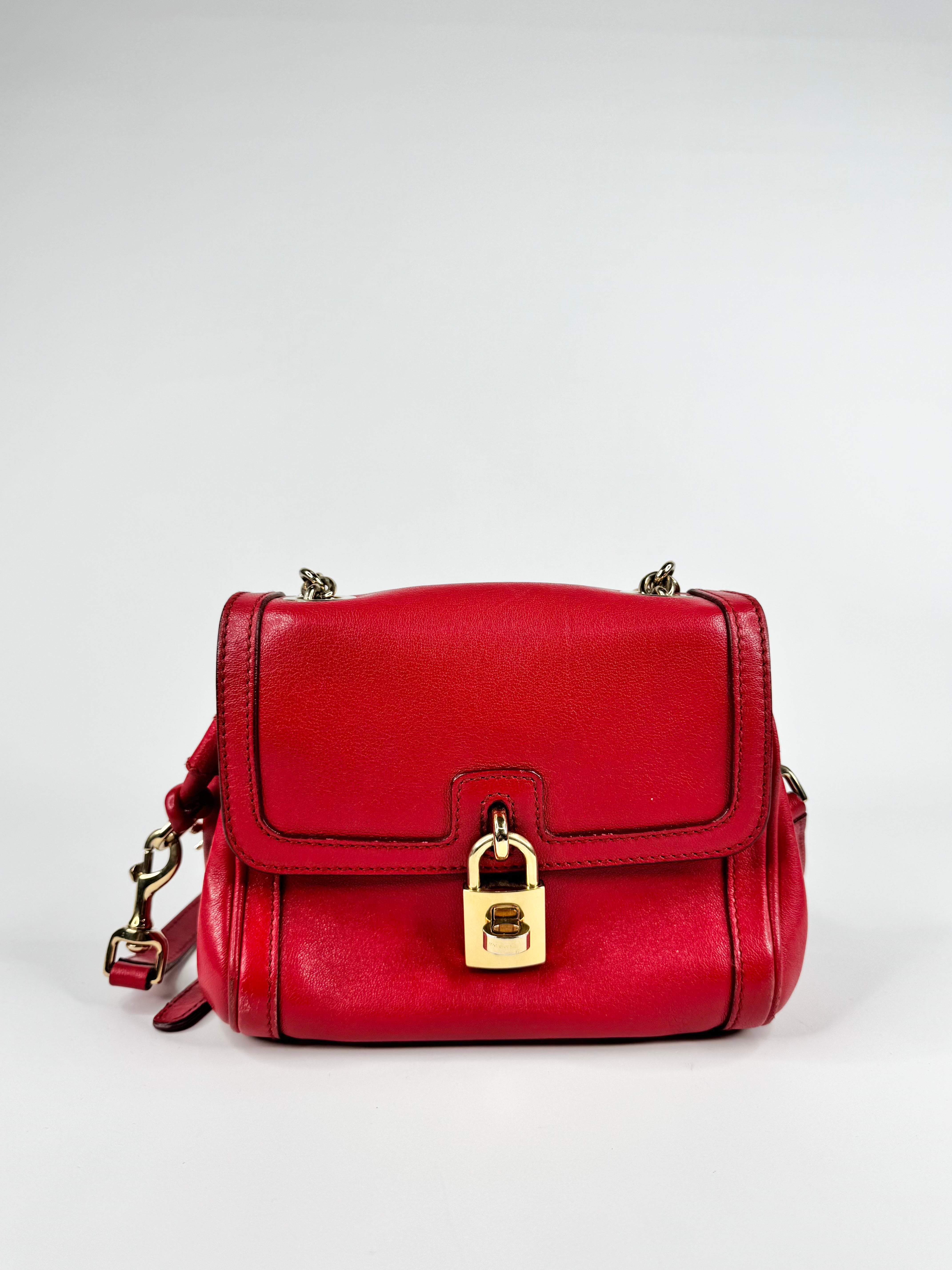 Red handbag with a gold lock on a white background