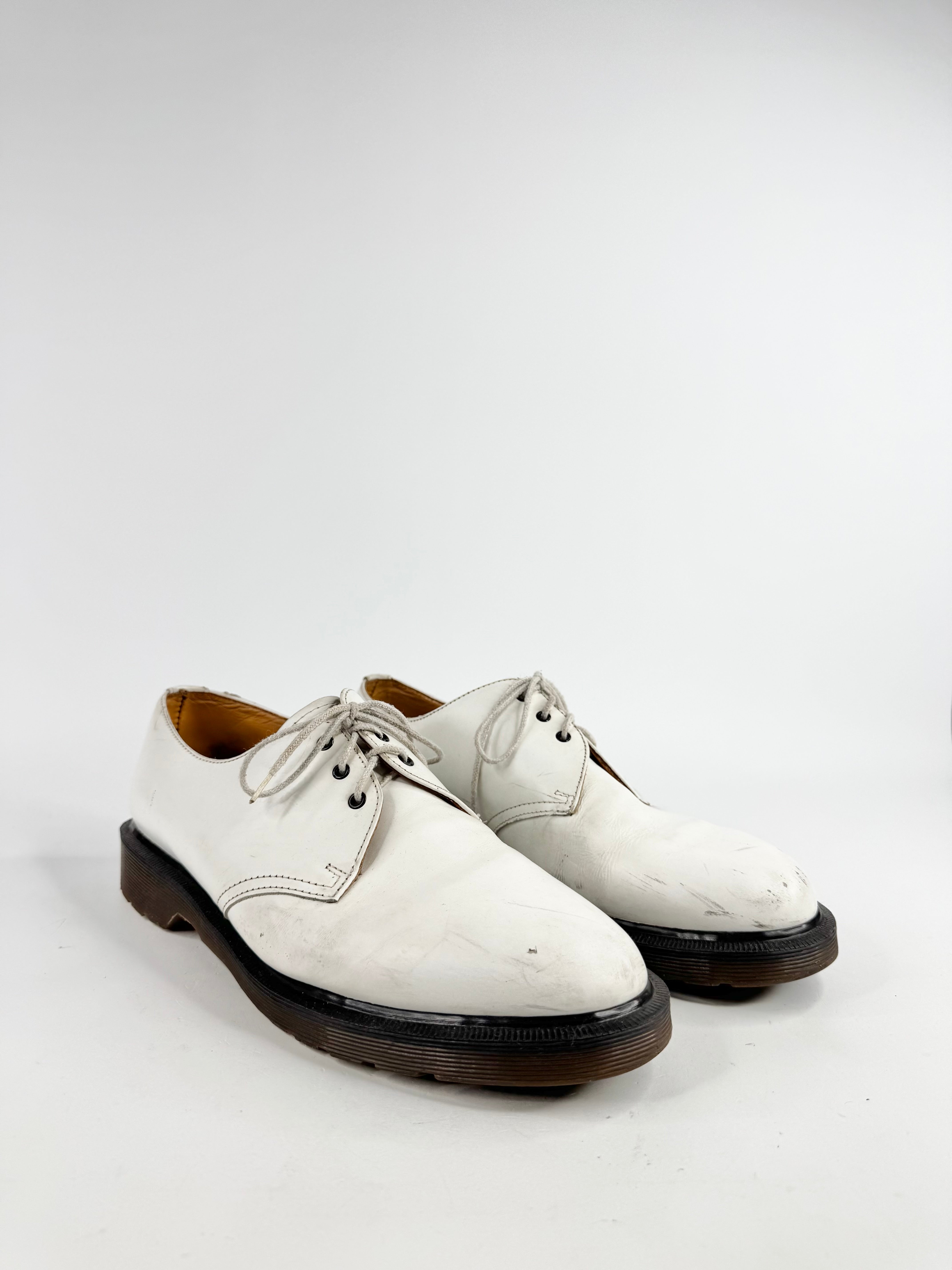 White leather shoes with black soles on a white background