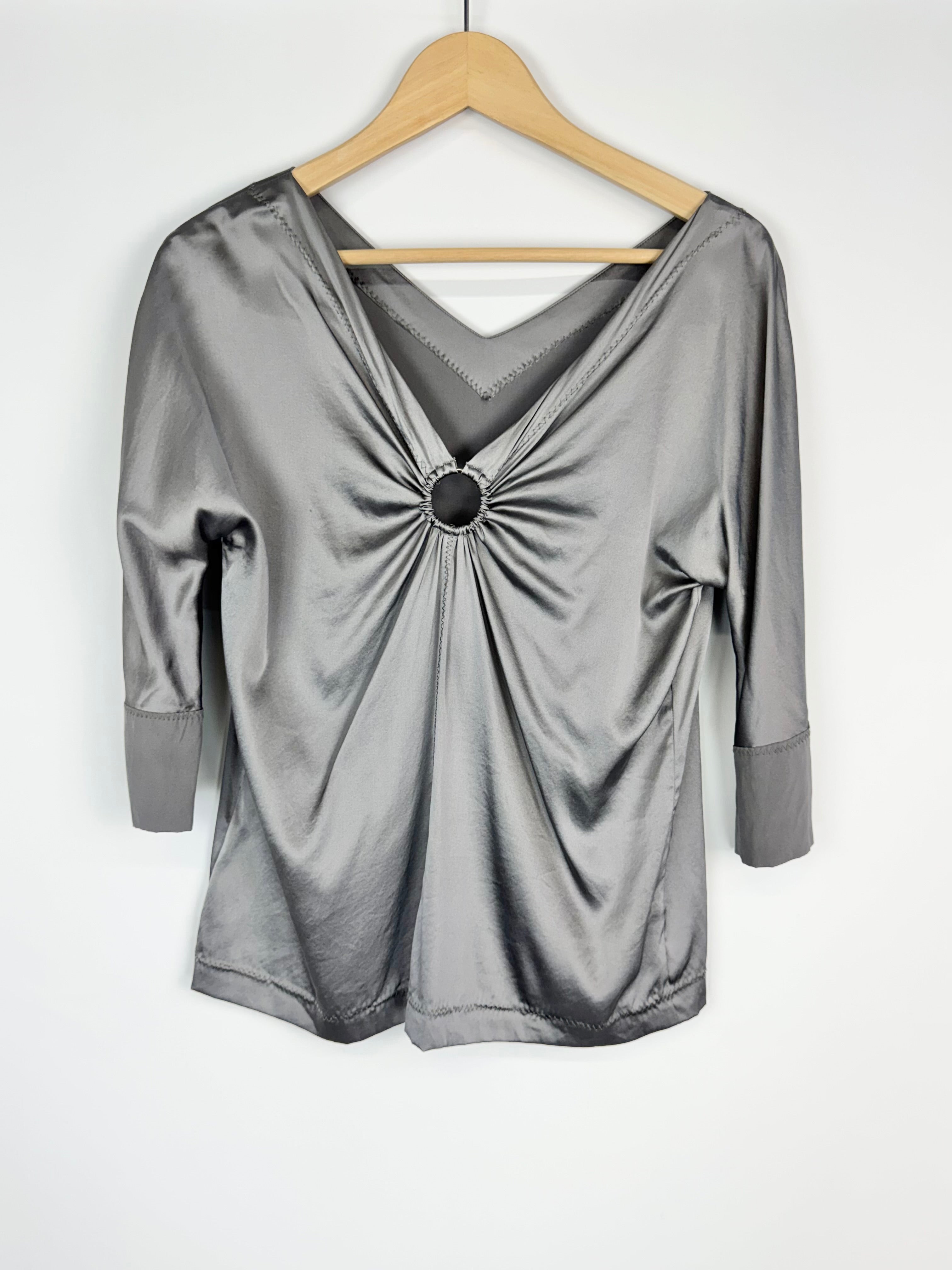 Silver metallic top on a wooden hanger against a white background
