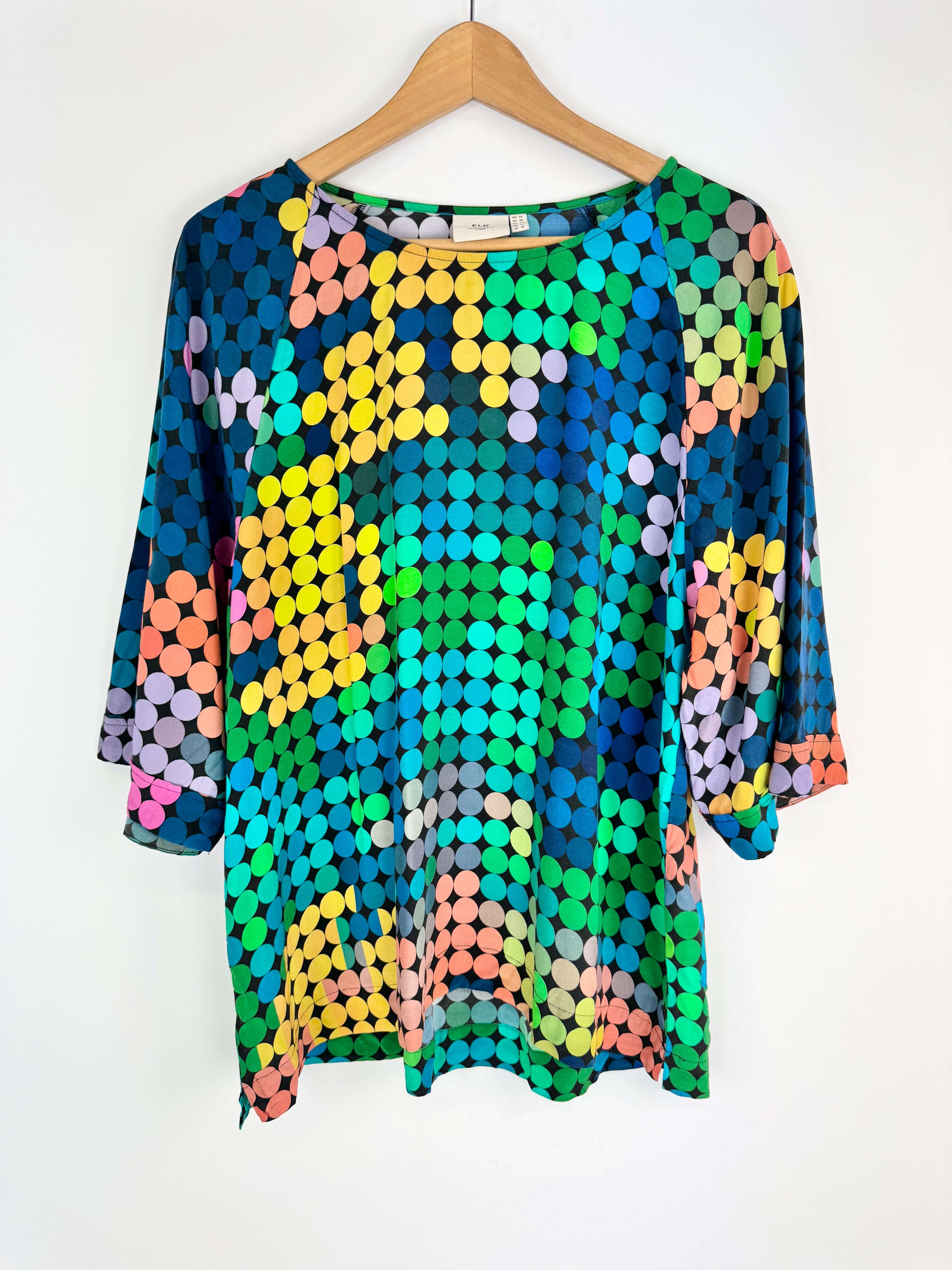 Colorful sequin top on a hanger against a white background