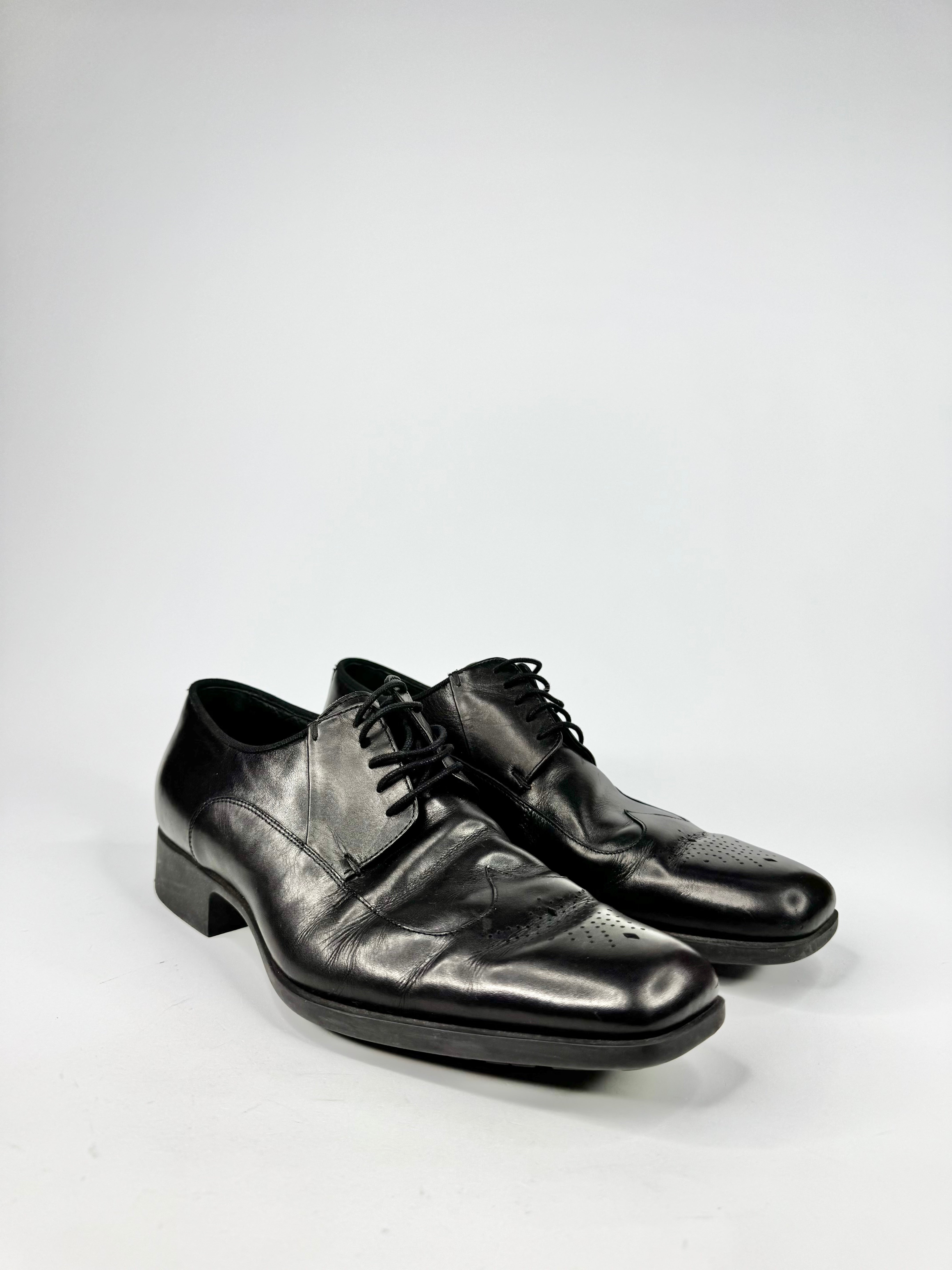 Pair of black leather dress shoes on a white background