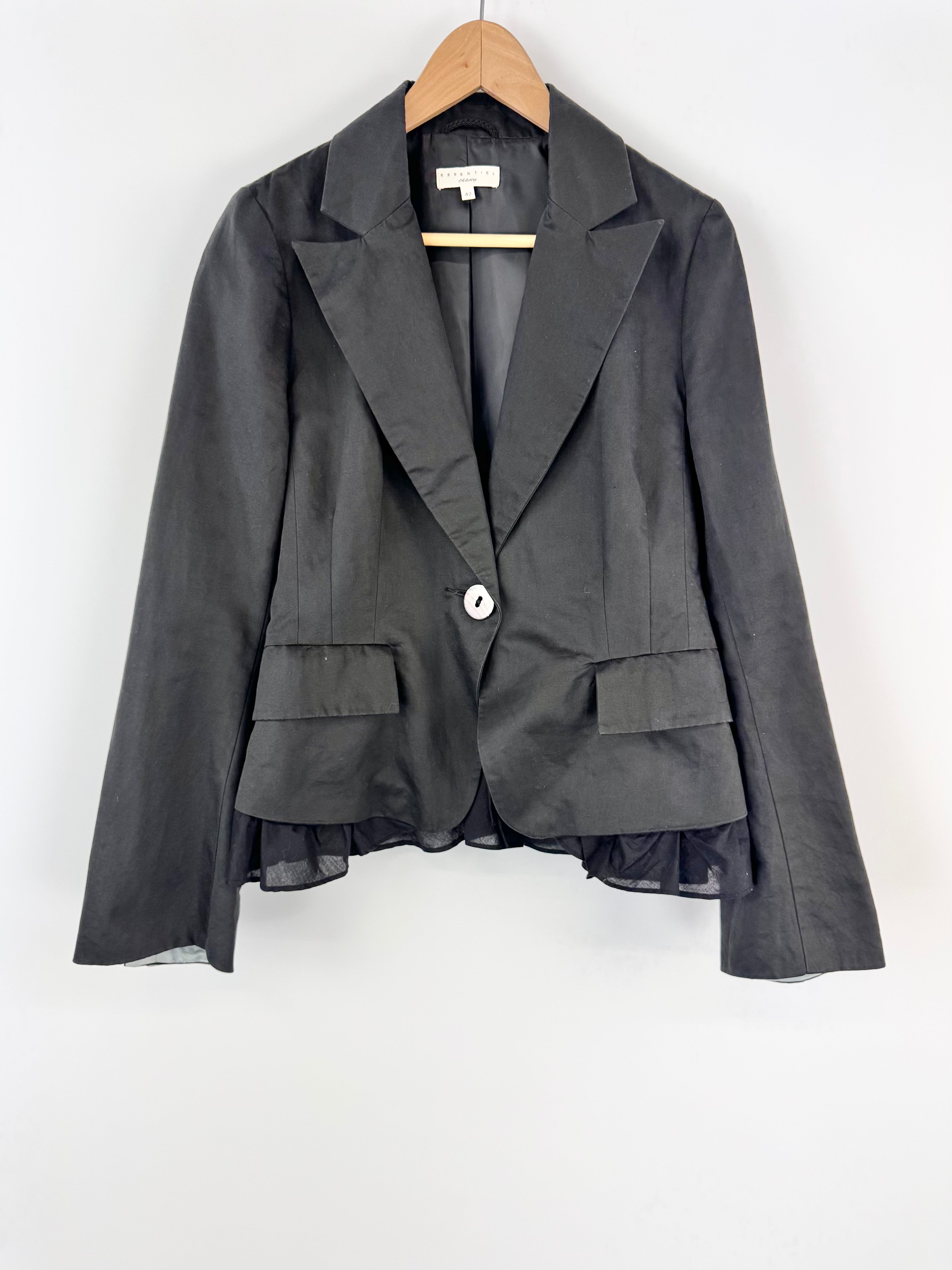 Black blazer with sheer overlay on a white background