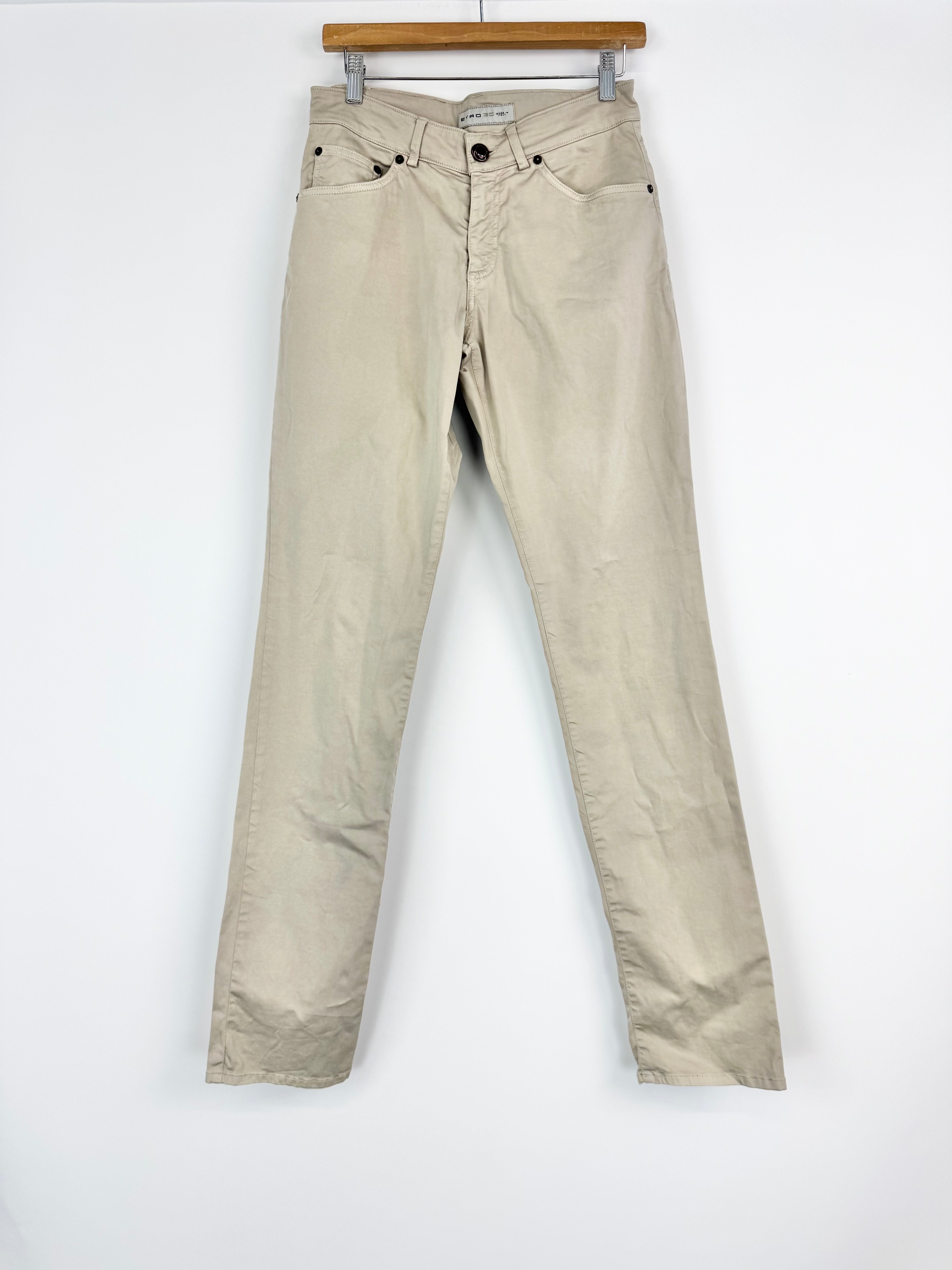 Beige pants on a hanger against a white background