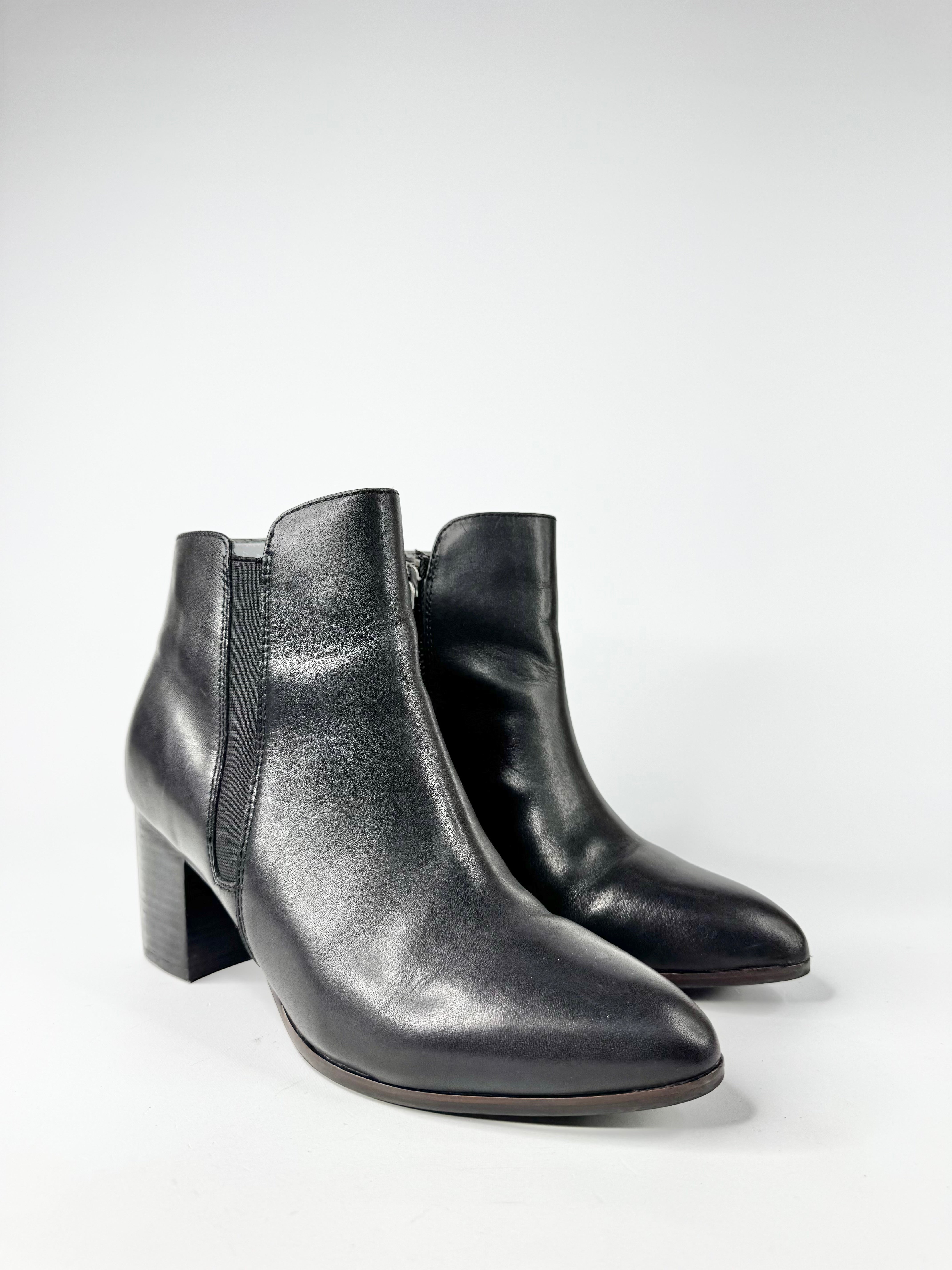 Pair of black leather ankle boots on a white background