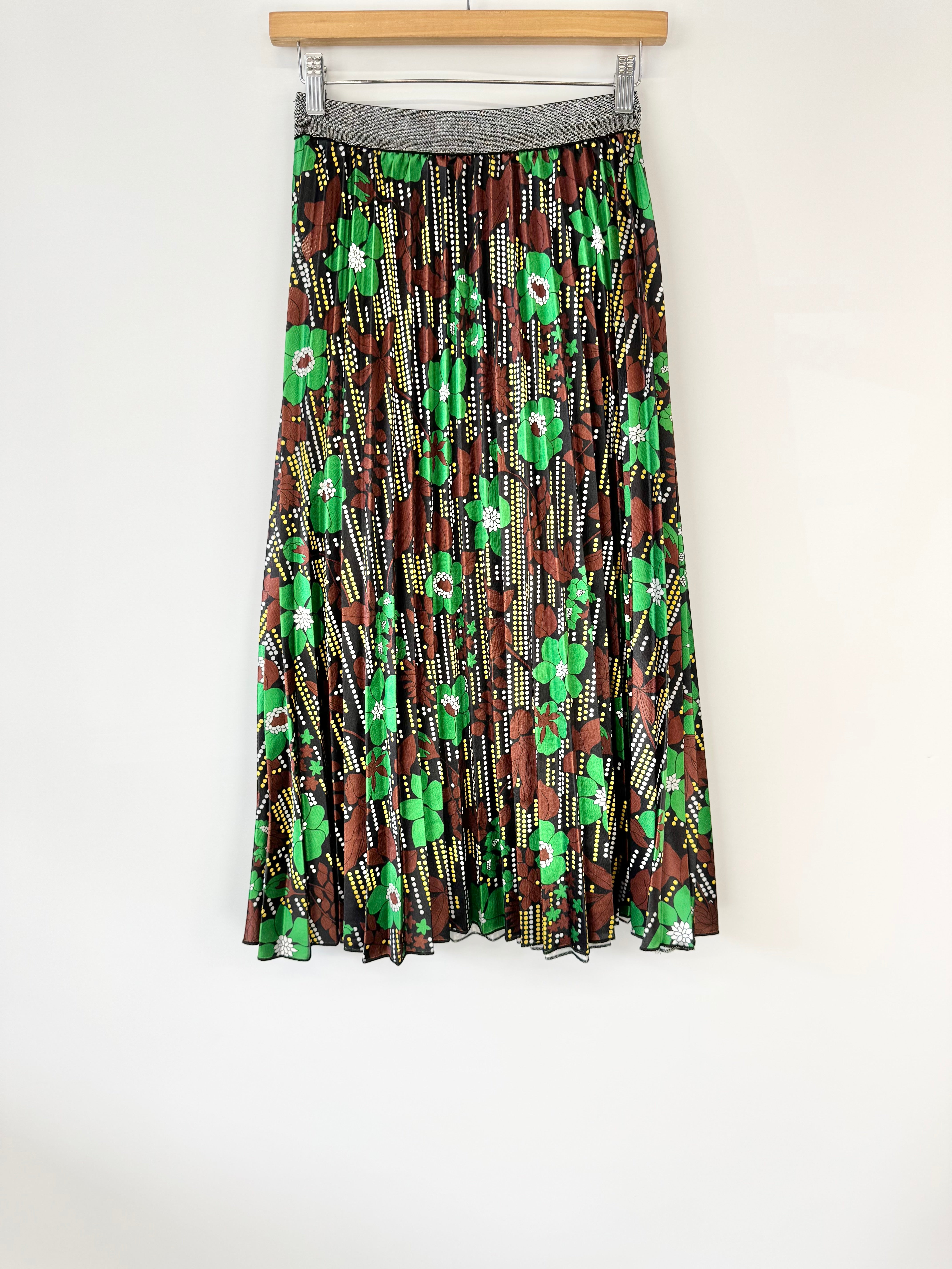 Skirt with green and brown pattern on a hanger against a white background