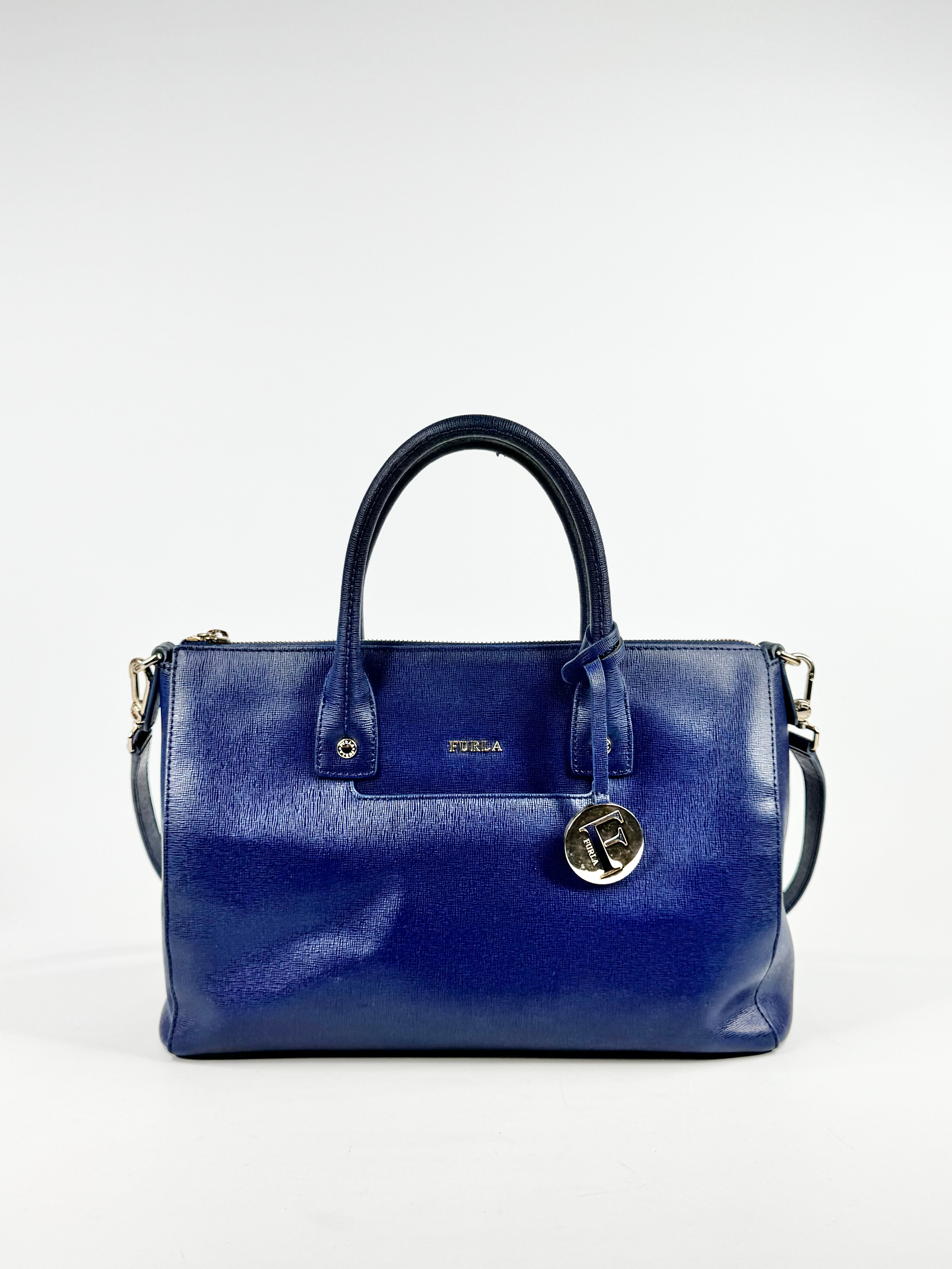 Blue handbag with a visible brand logo on a white background