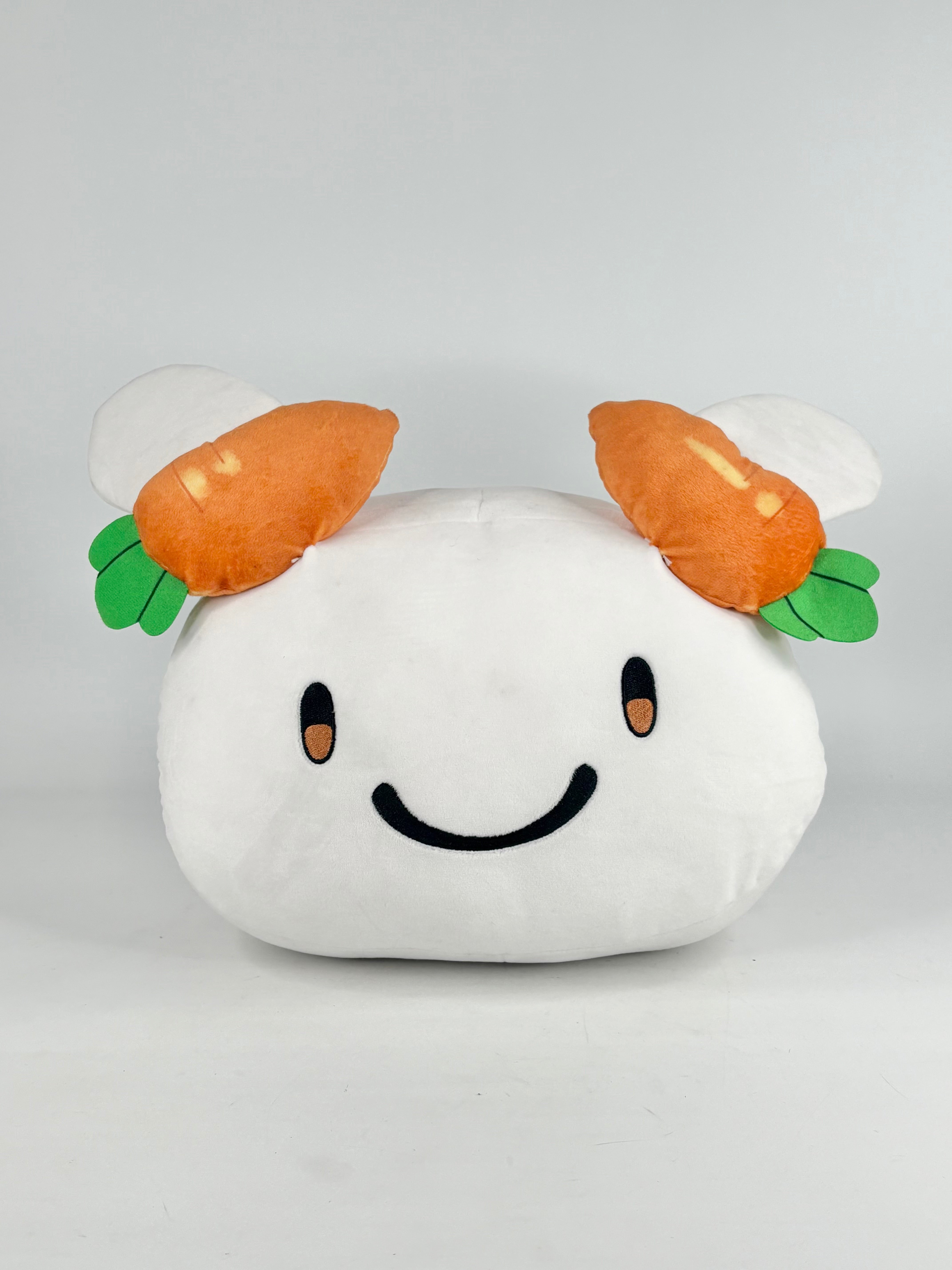 Plush toy shaped like a ghost with carrot horns on a light gray background