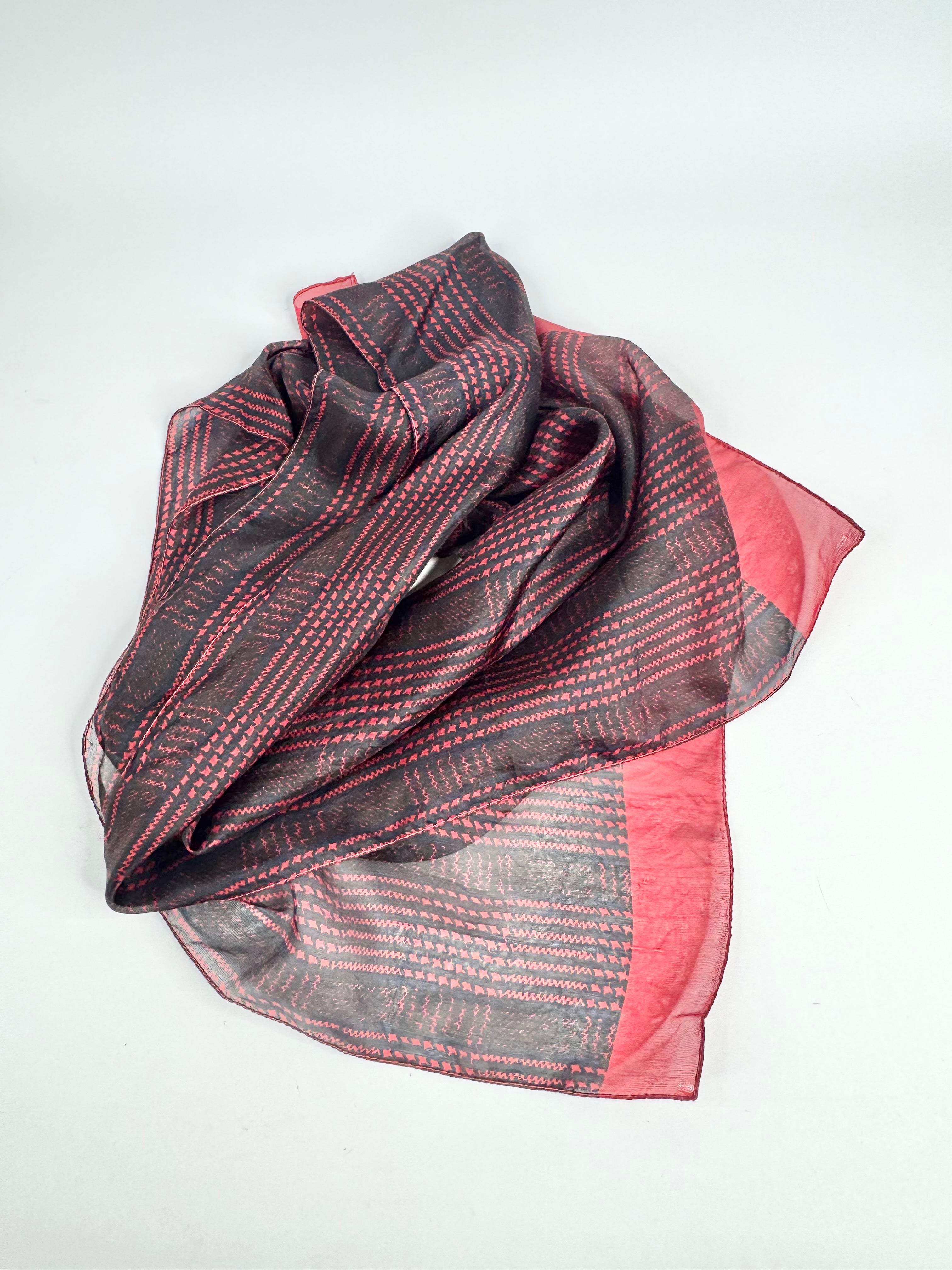 Folded scarf with pink and gray pattern on a white background