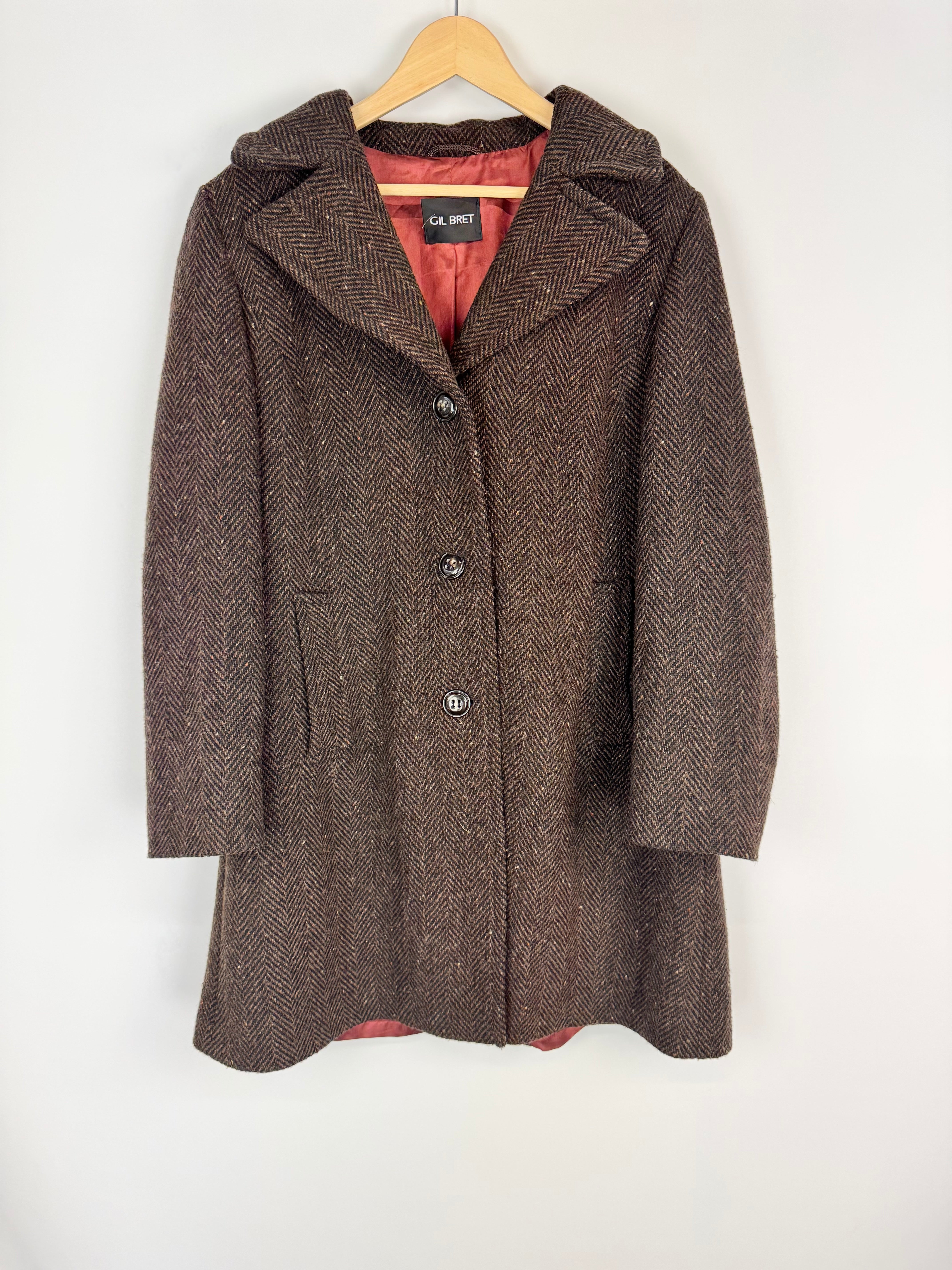 Brown textured coat on a hanger against a white background