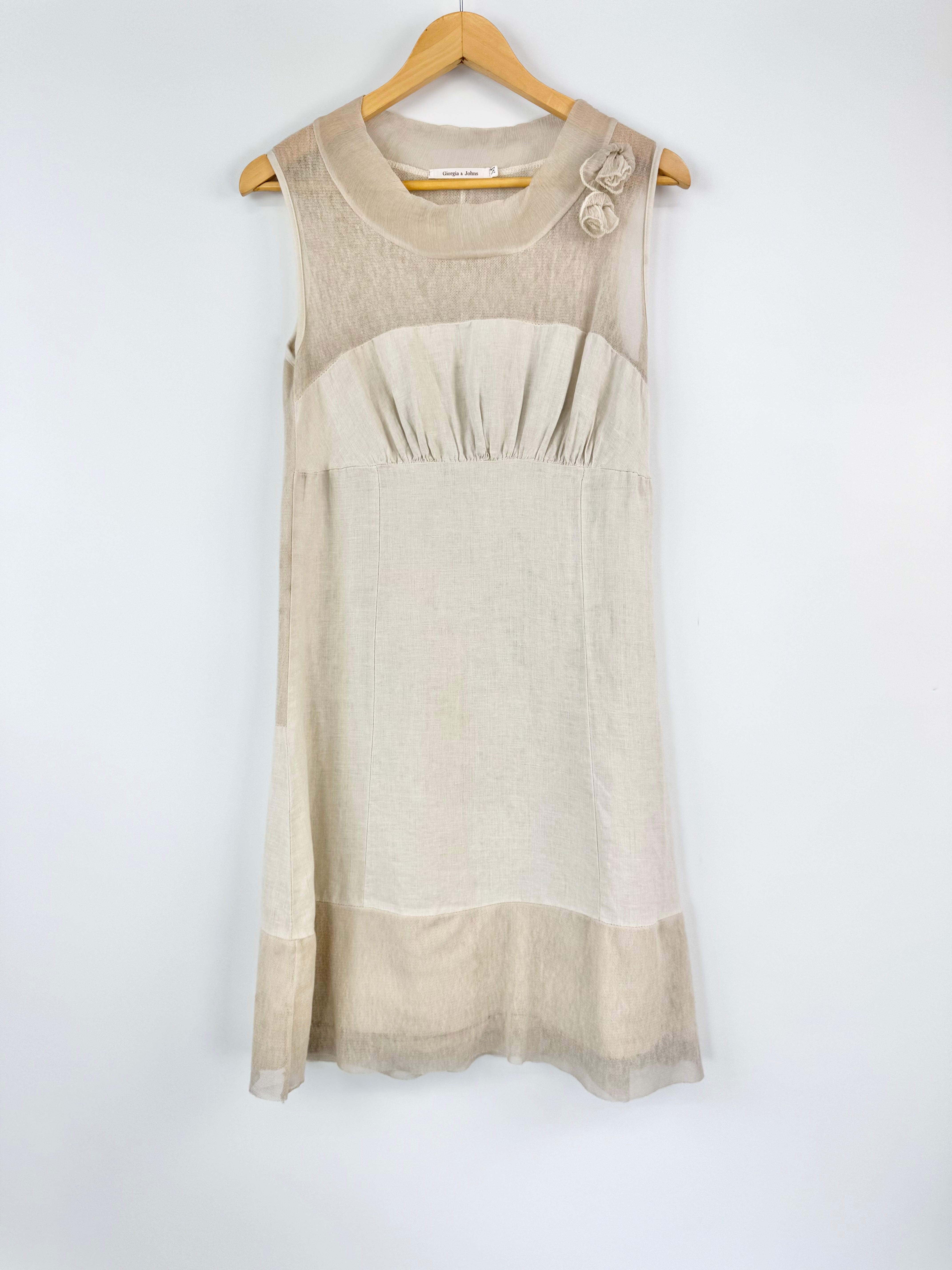Beige sleeveless dress on a hanger against a white background