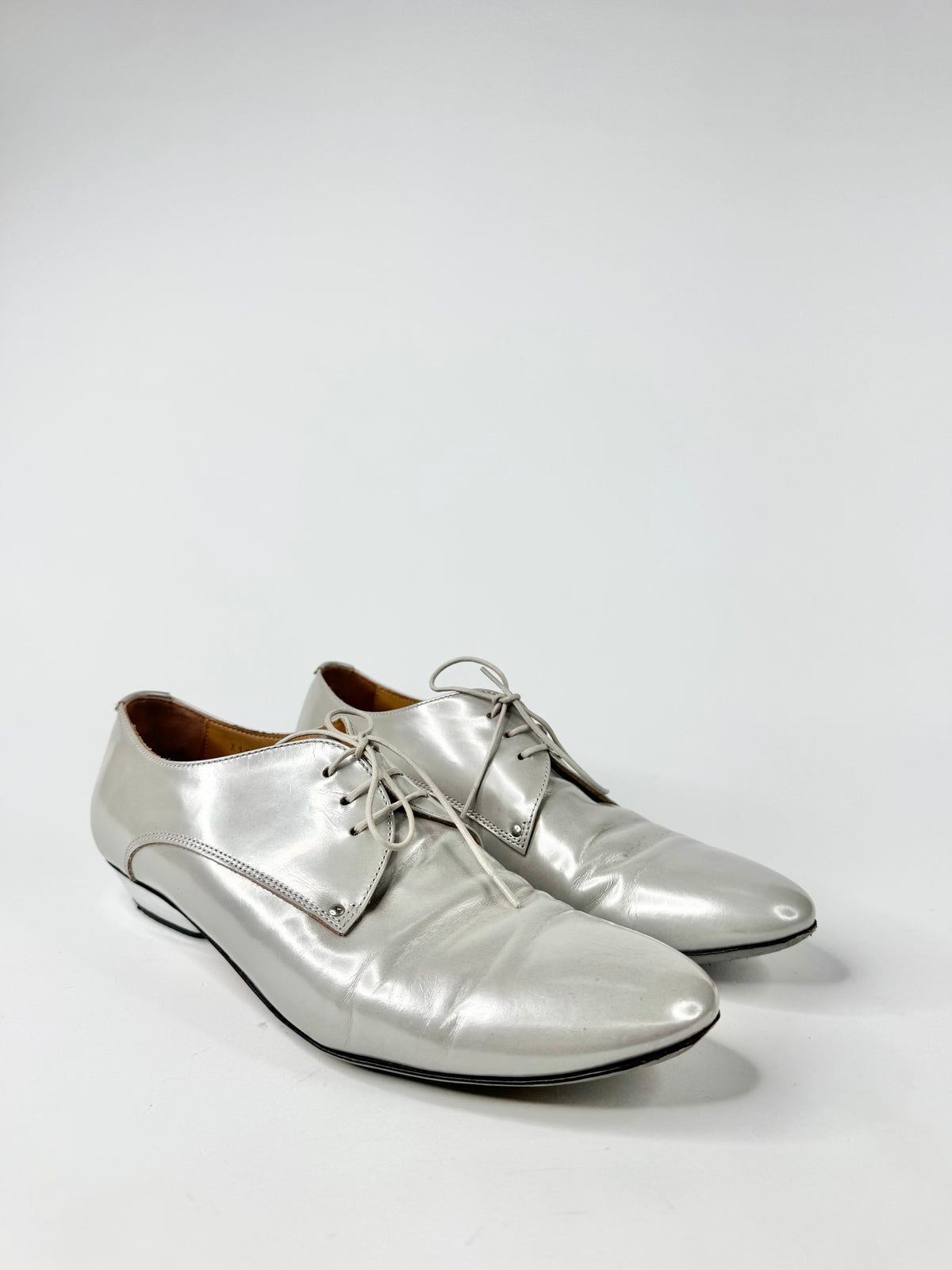 Pair of silver dress shoes on a white background