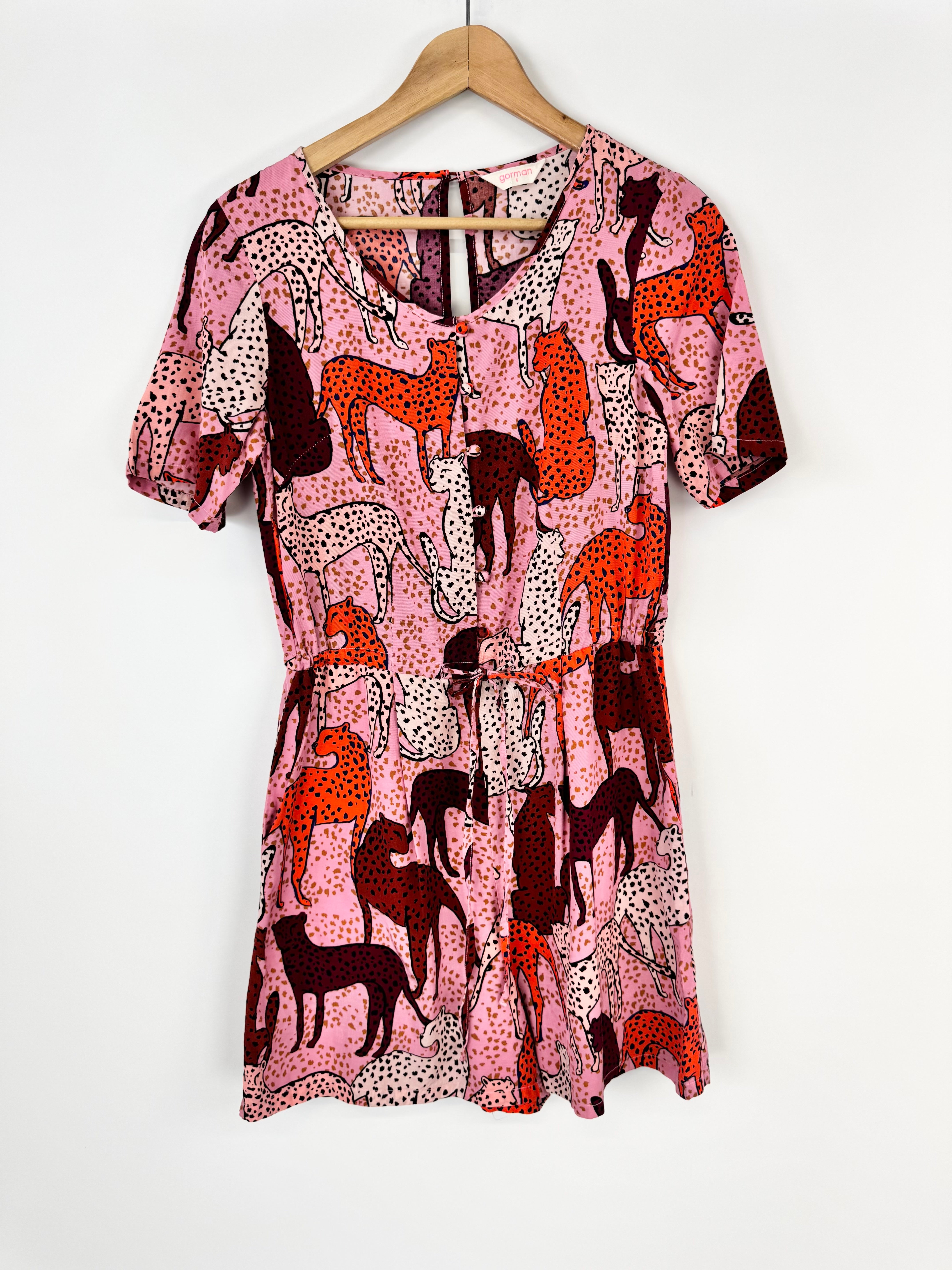 Dress with animal pattern on a hanger against a white background