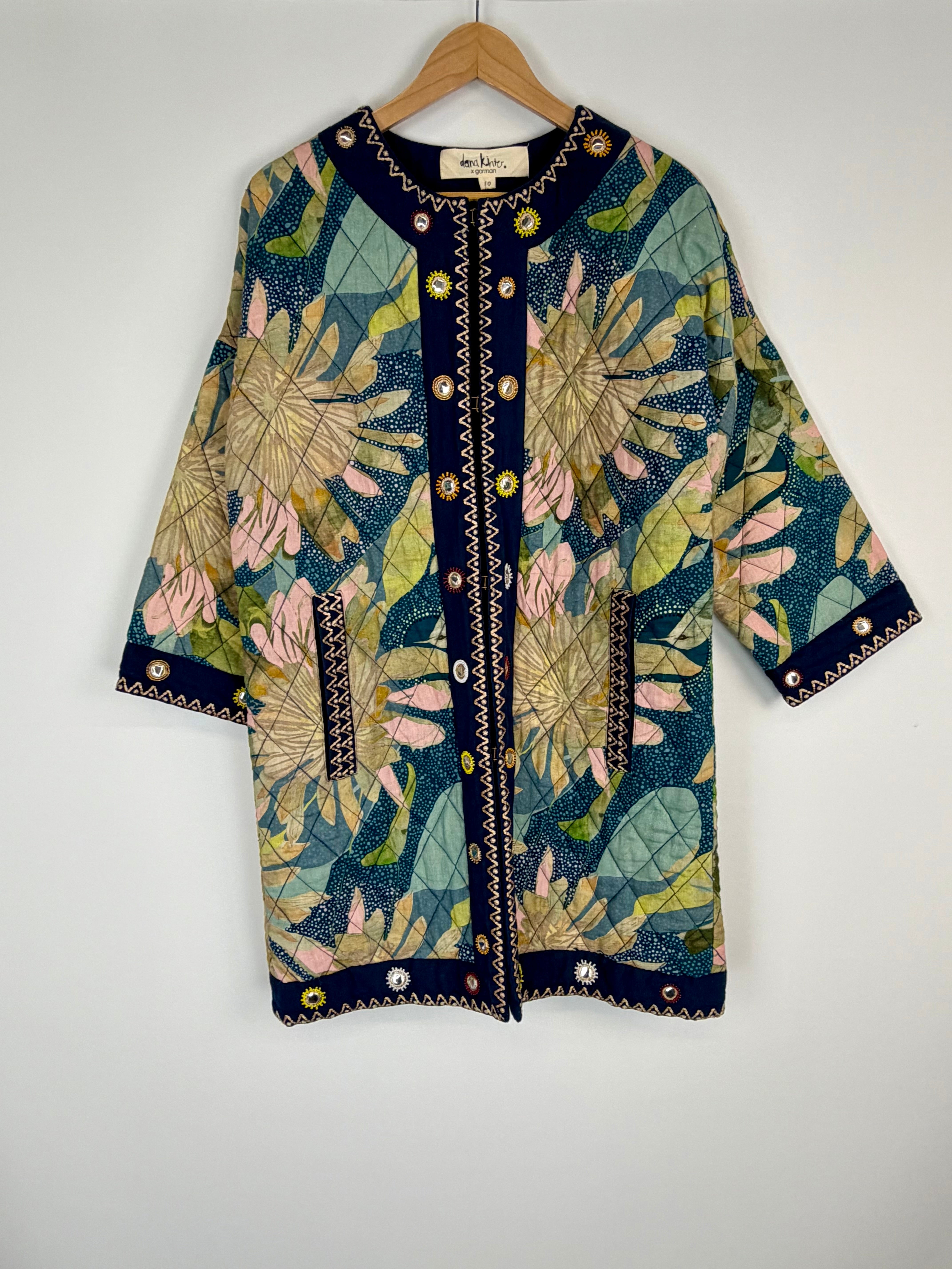 Floral patterned cardigan on a hanger against a white background