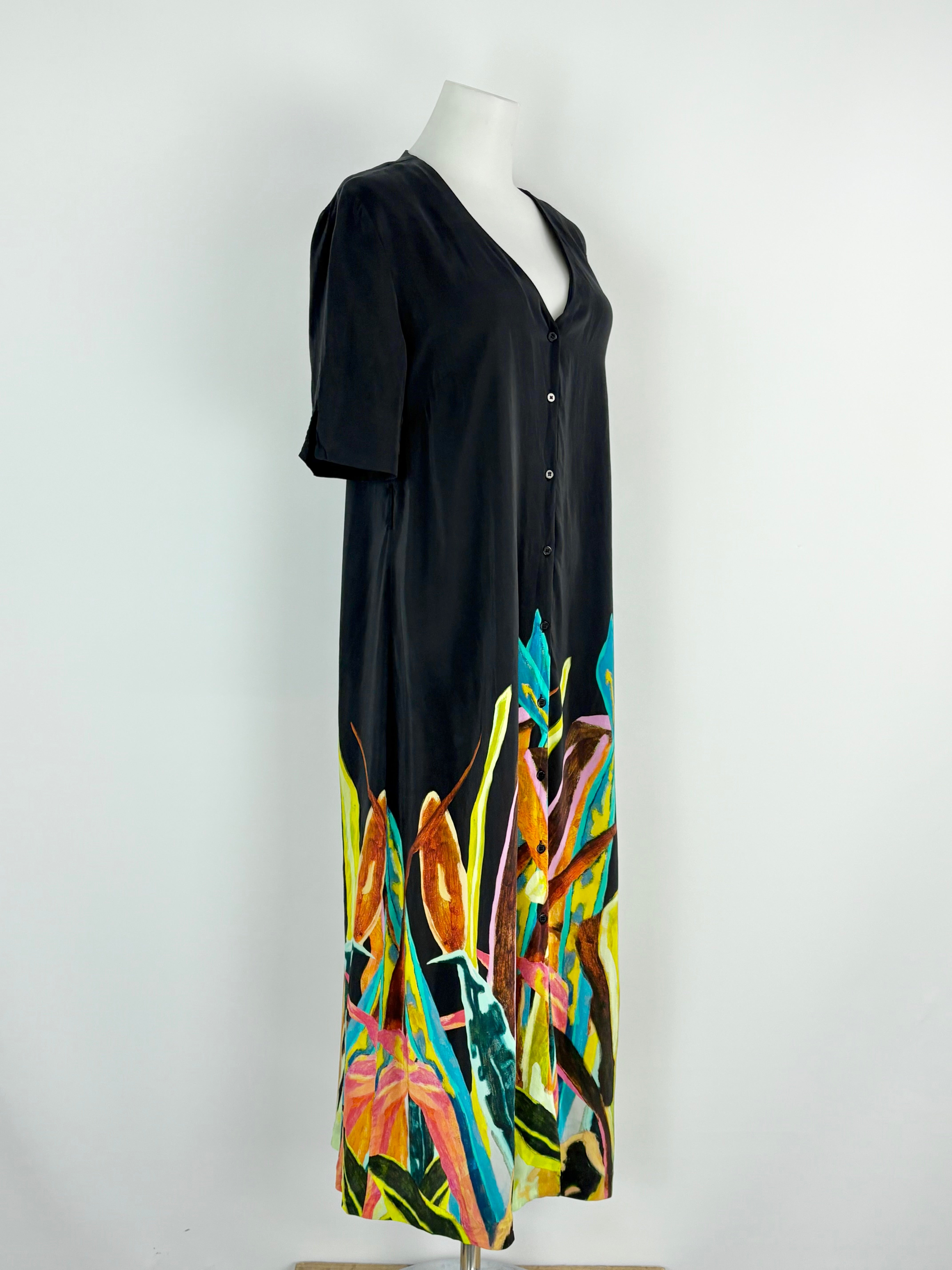 Black dress with colorful abstract design on a mannequin against a white background