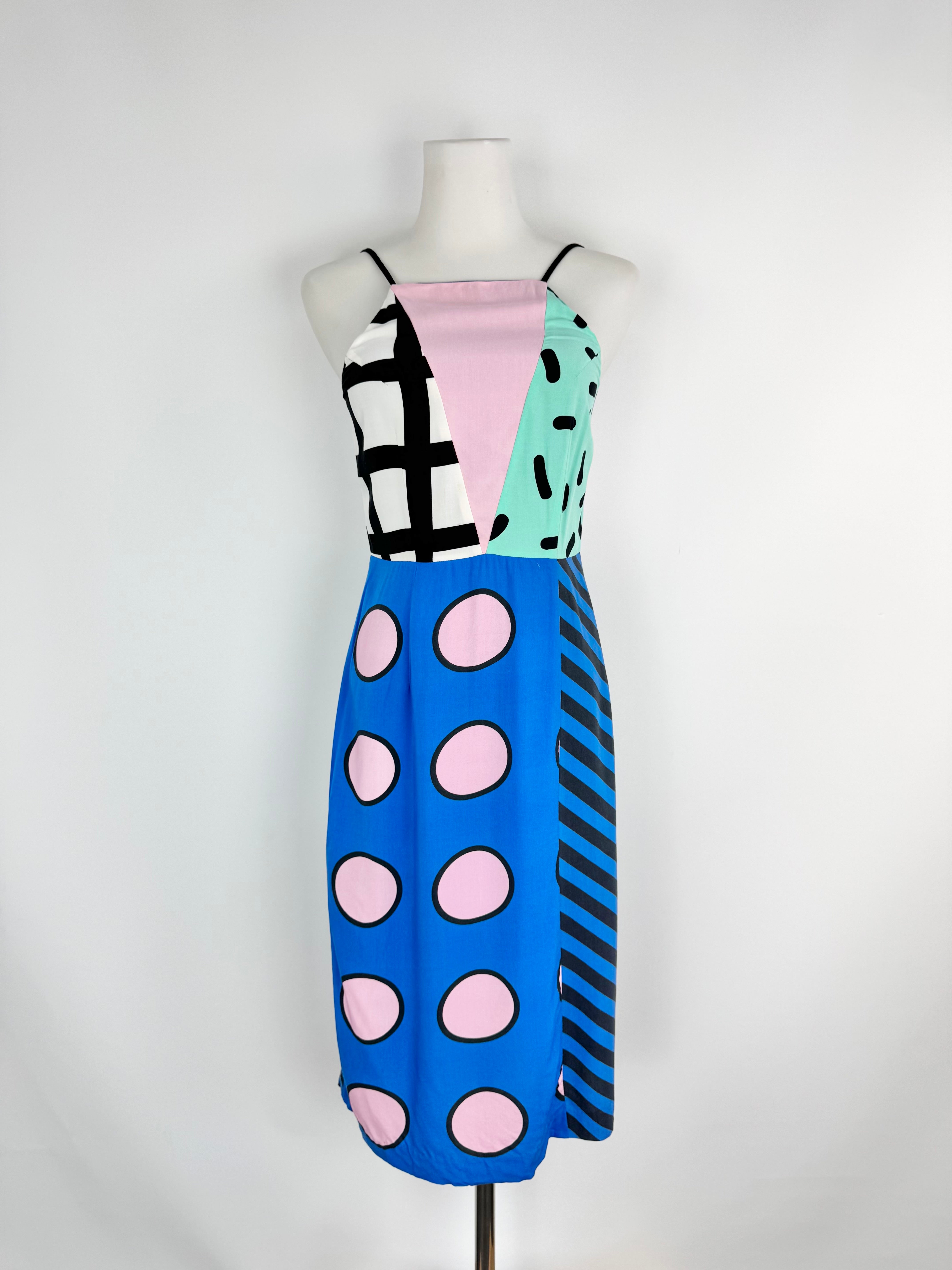 Colorful dress with geometric patterns on a mannequin against a white background