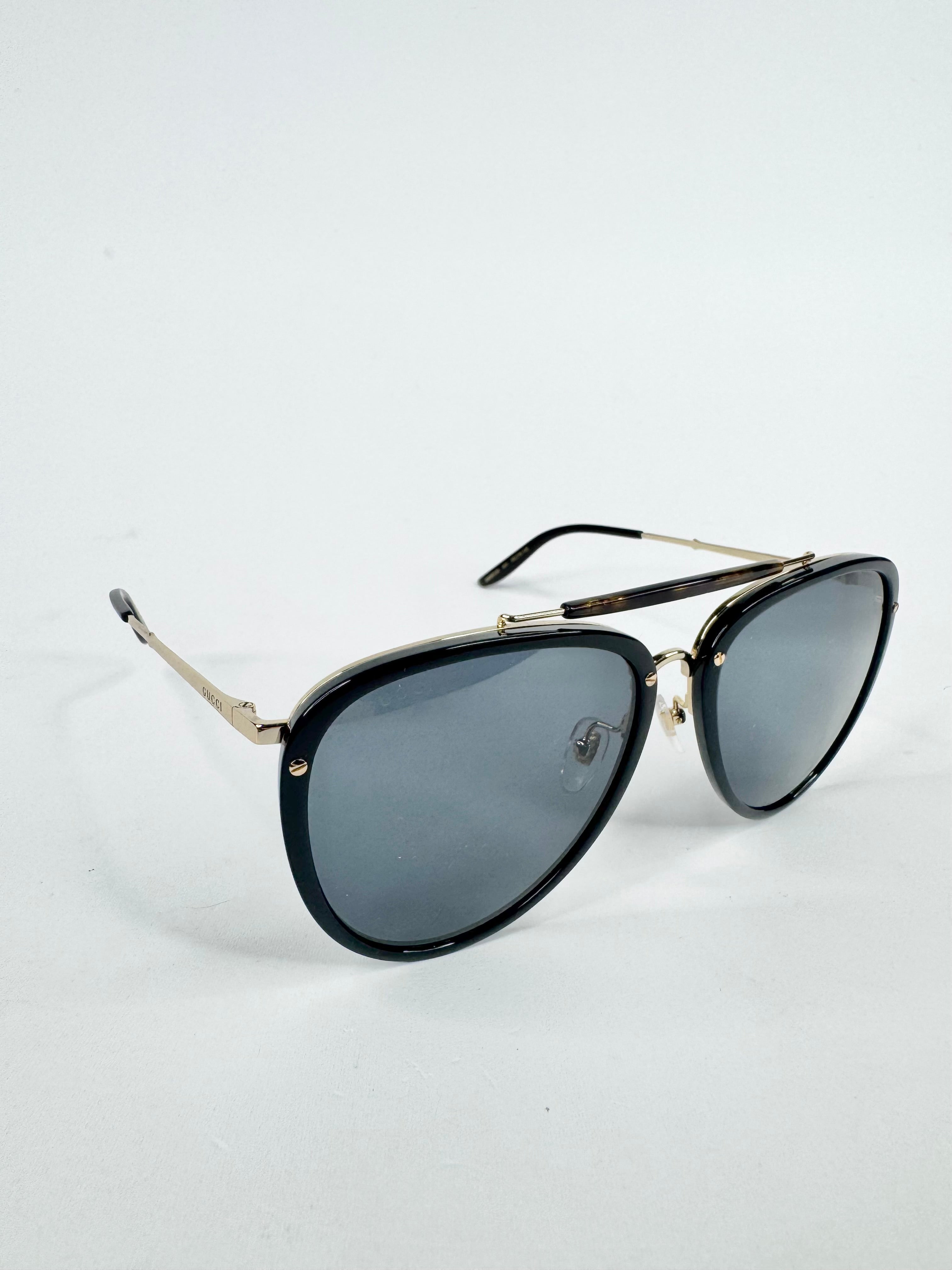 Black sunglasses with gold frames on a white background