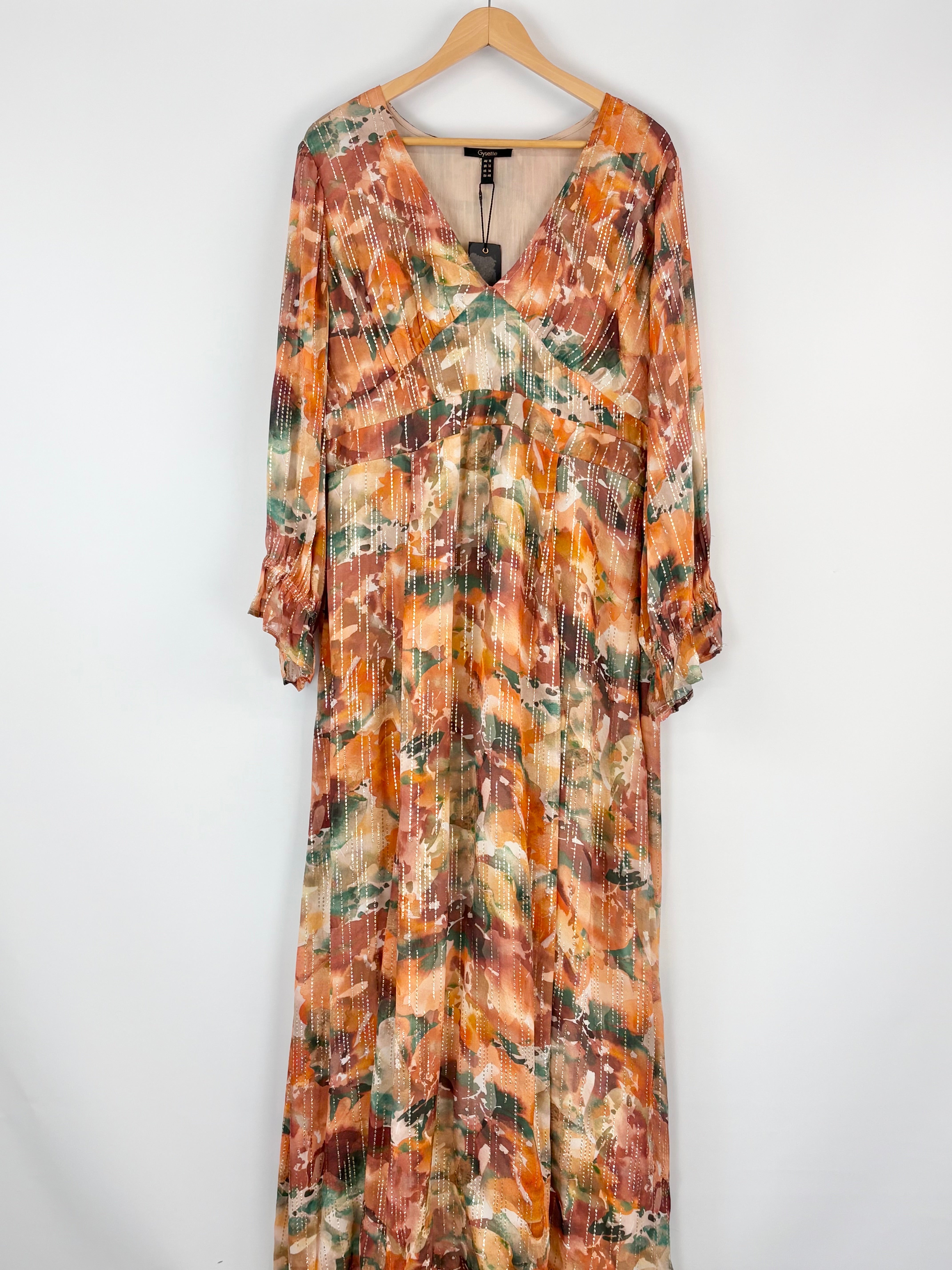 Long floral dress on a hanger against a white background
