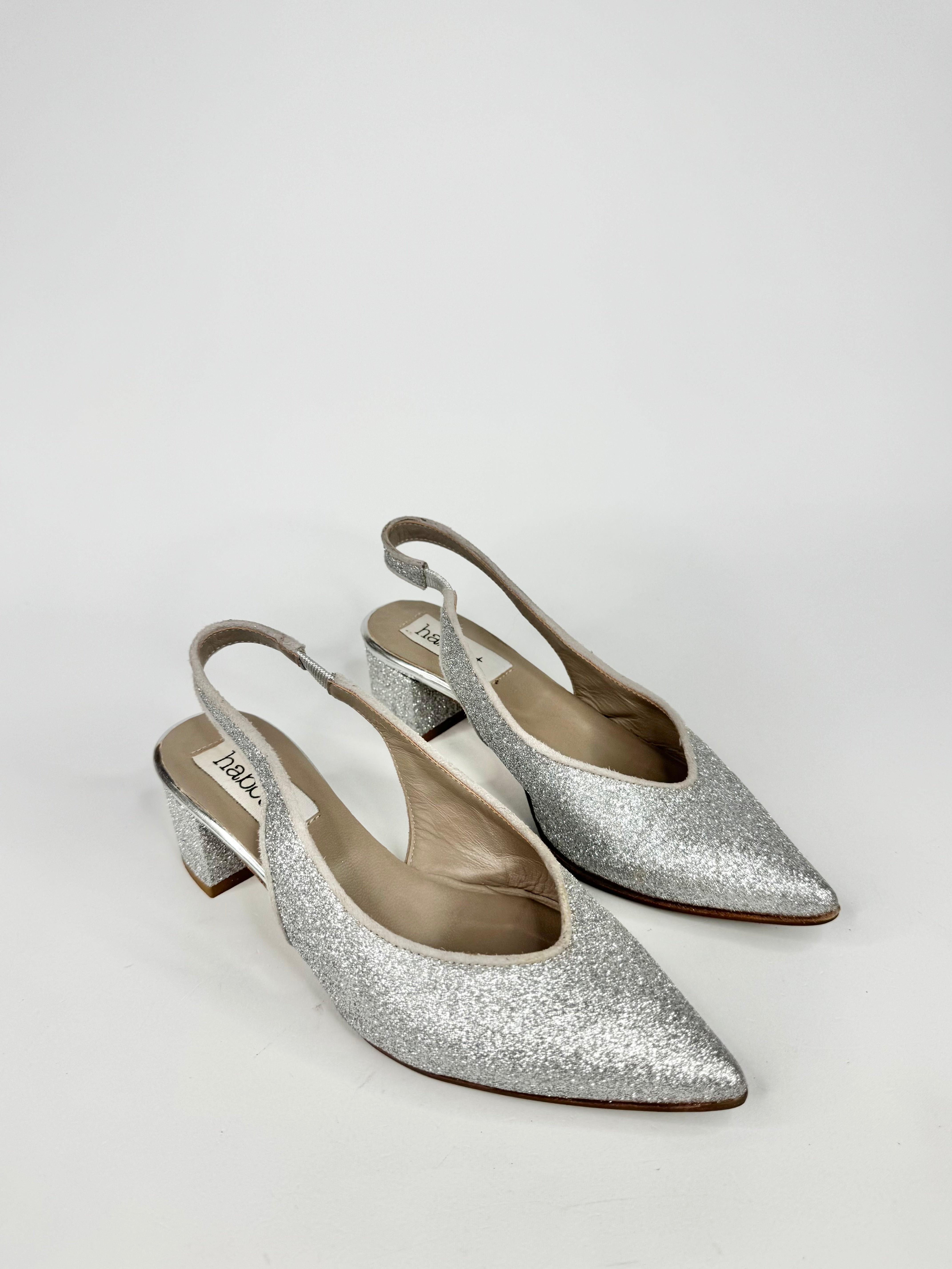 Silver glitter slingback shoes on a white background