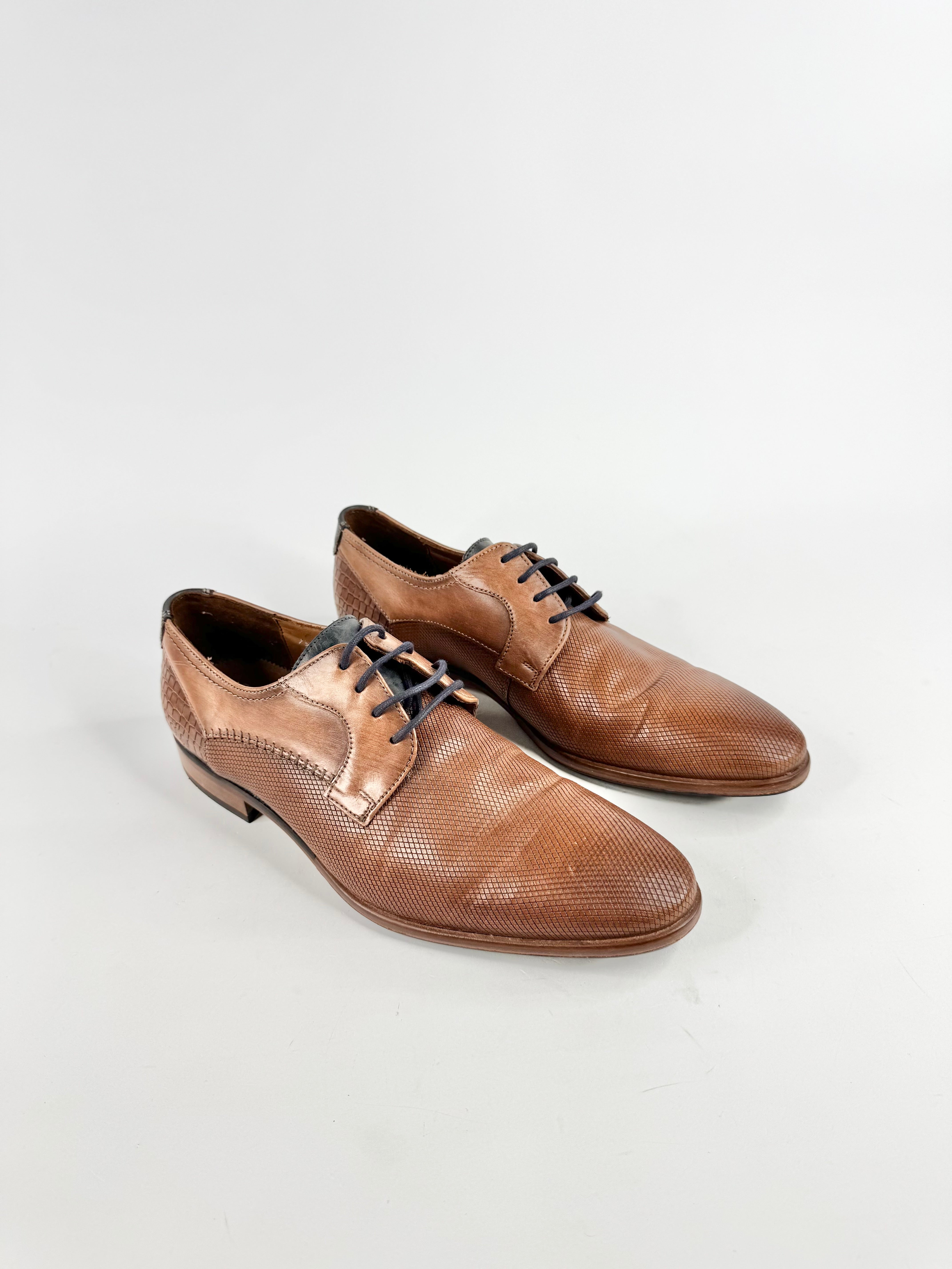 Pair of brown leather dress shoes on a white background