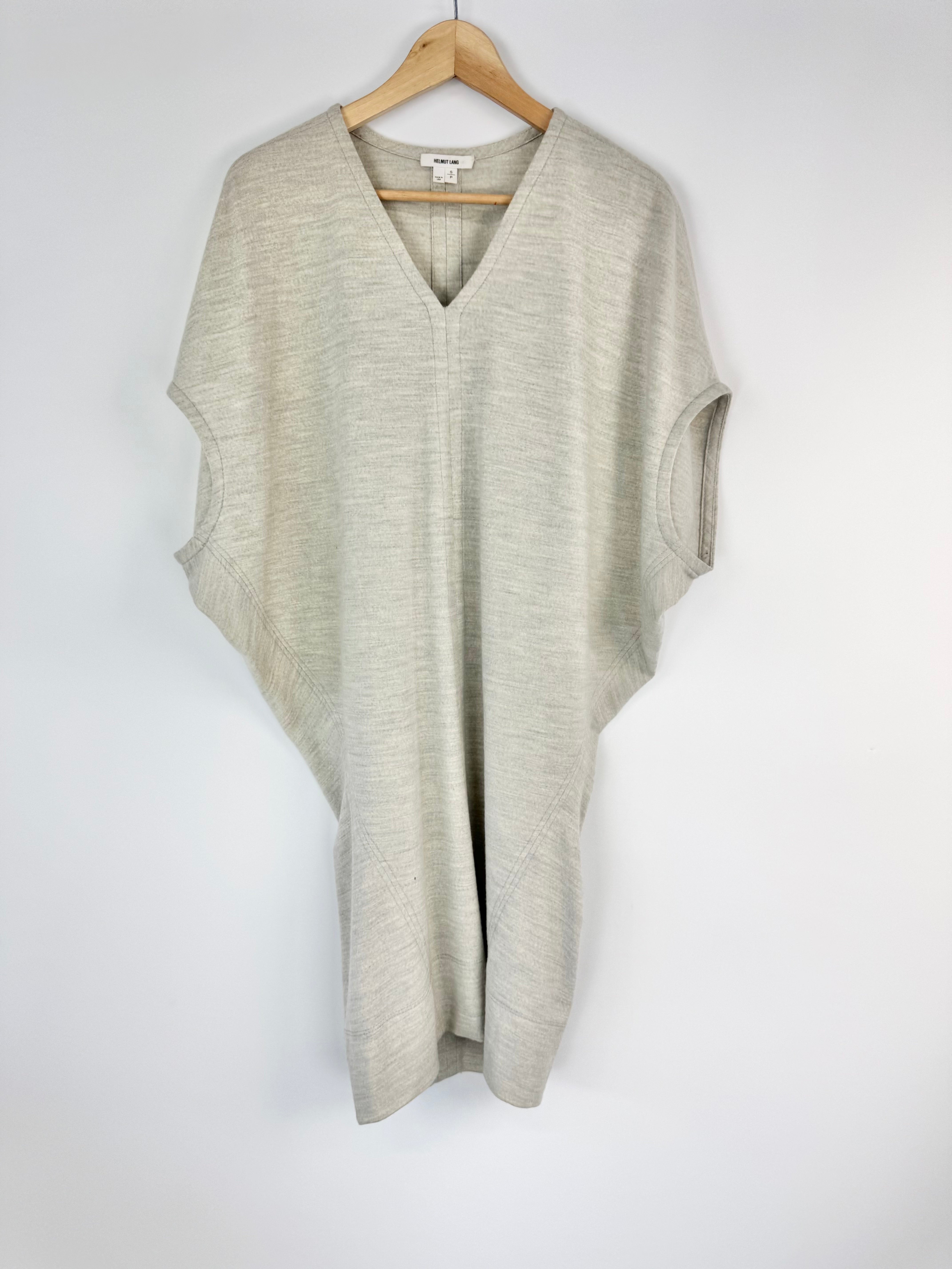 Light gray sleeveless tunic on a wooden hanger against a white background