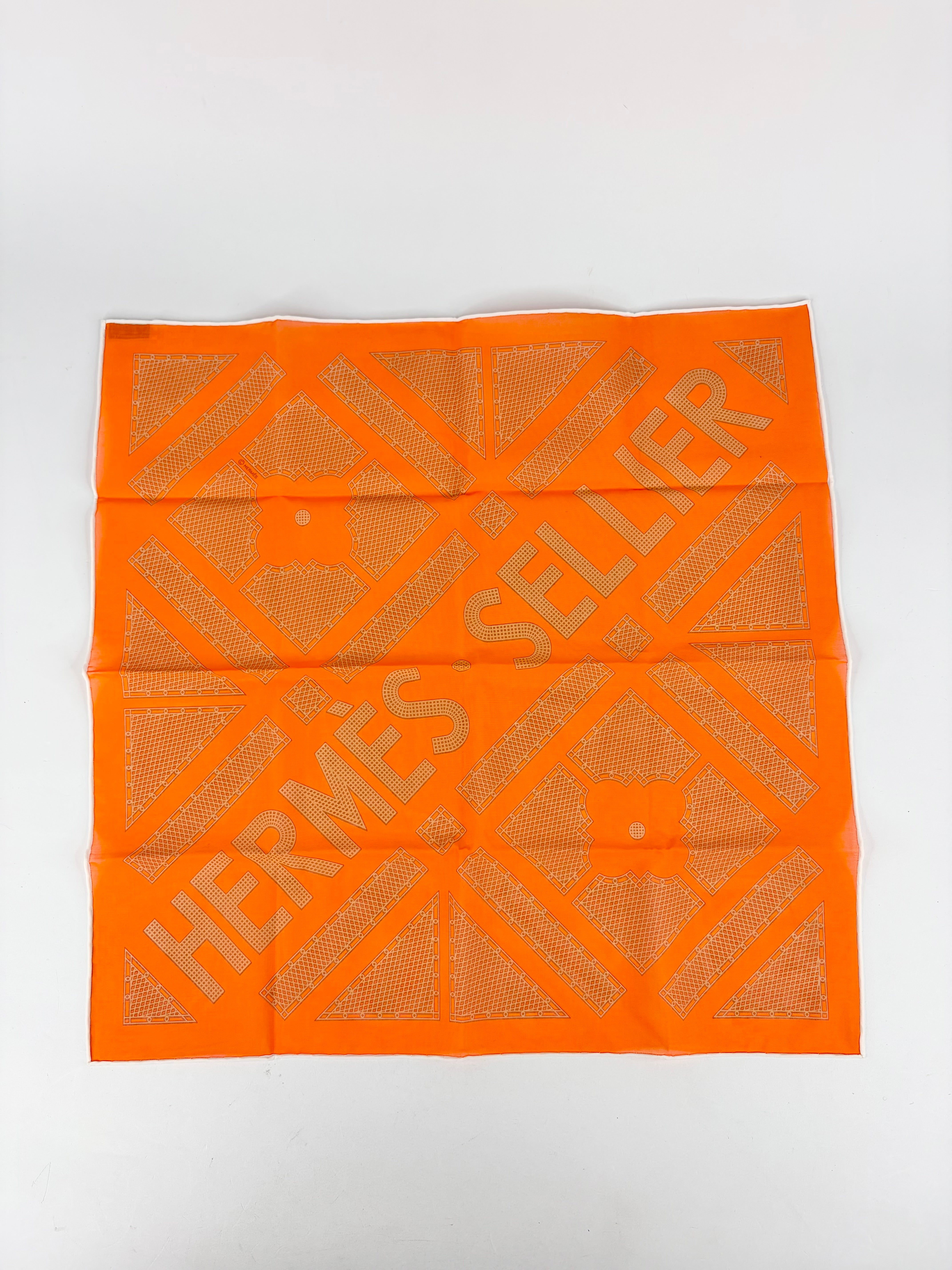 Orange Hermes Sellier scarf with geometric pattern on a white background