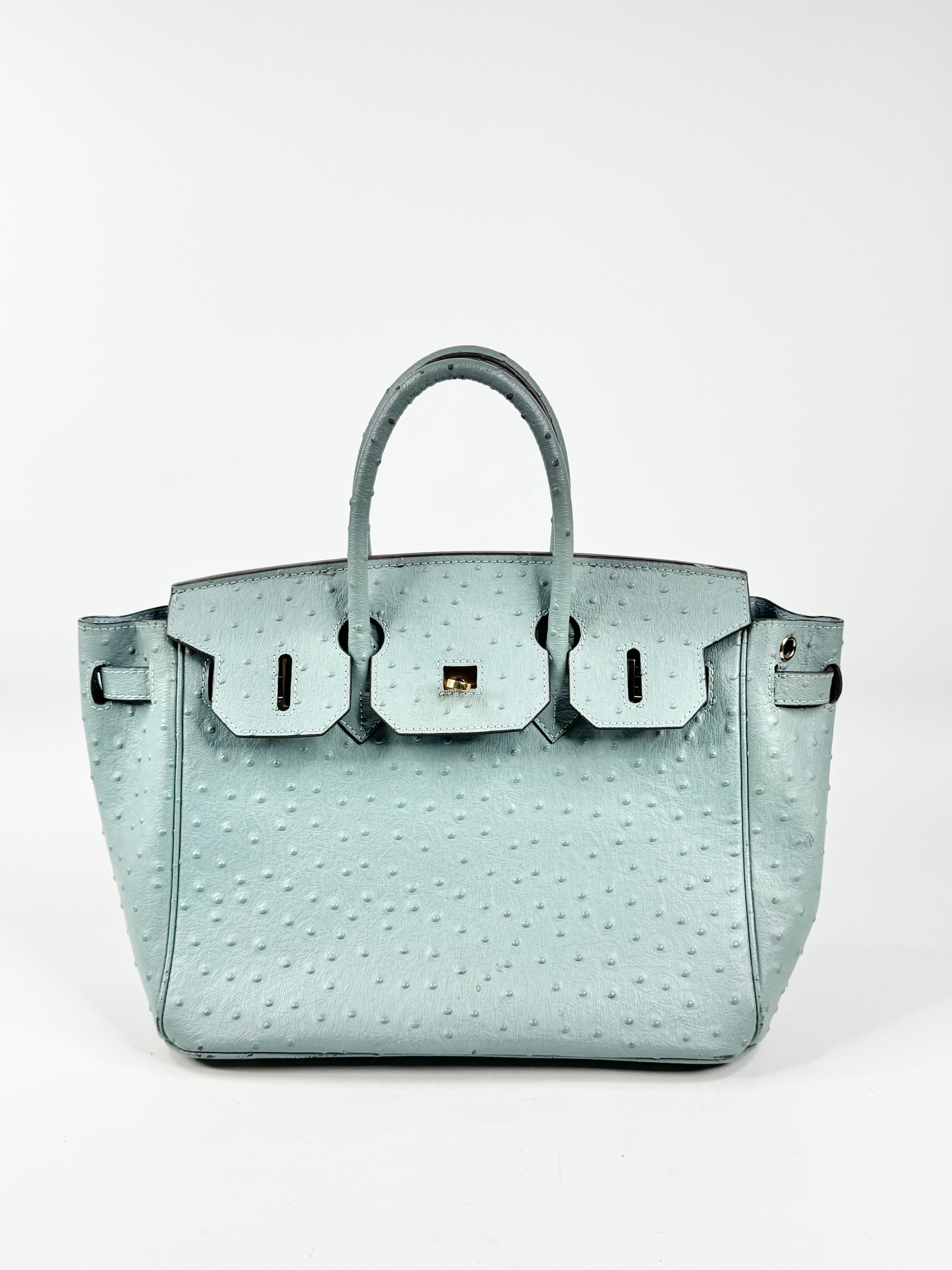 Light blue handbag with a textured pattern on a white background