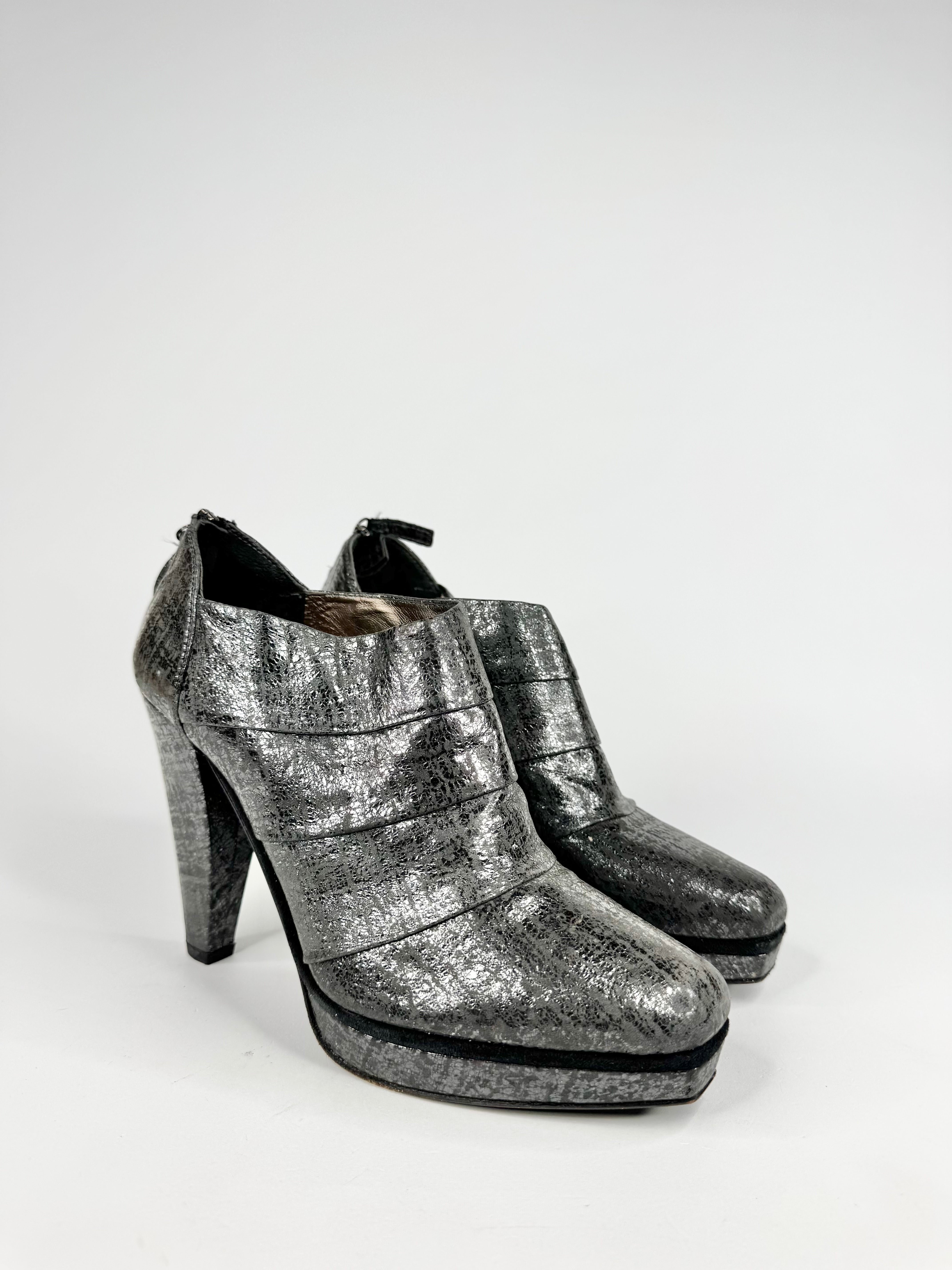 Pair of silver high-heeled shoes on a white background