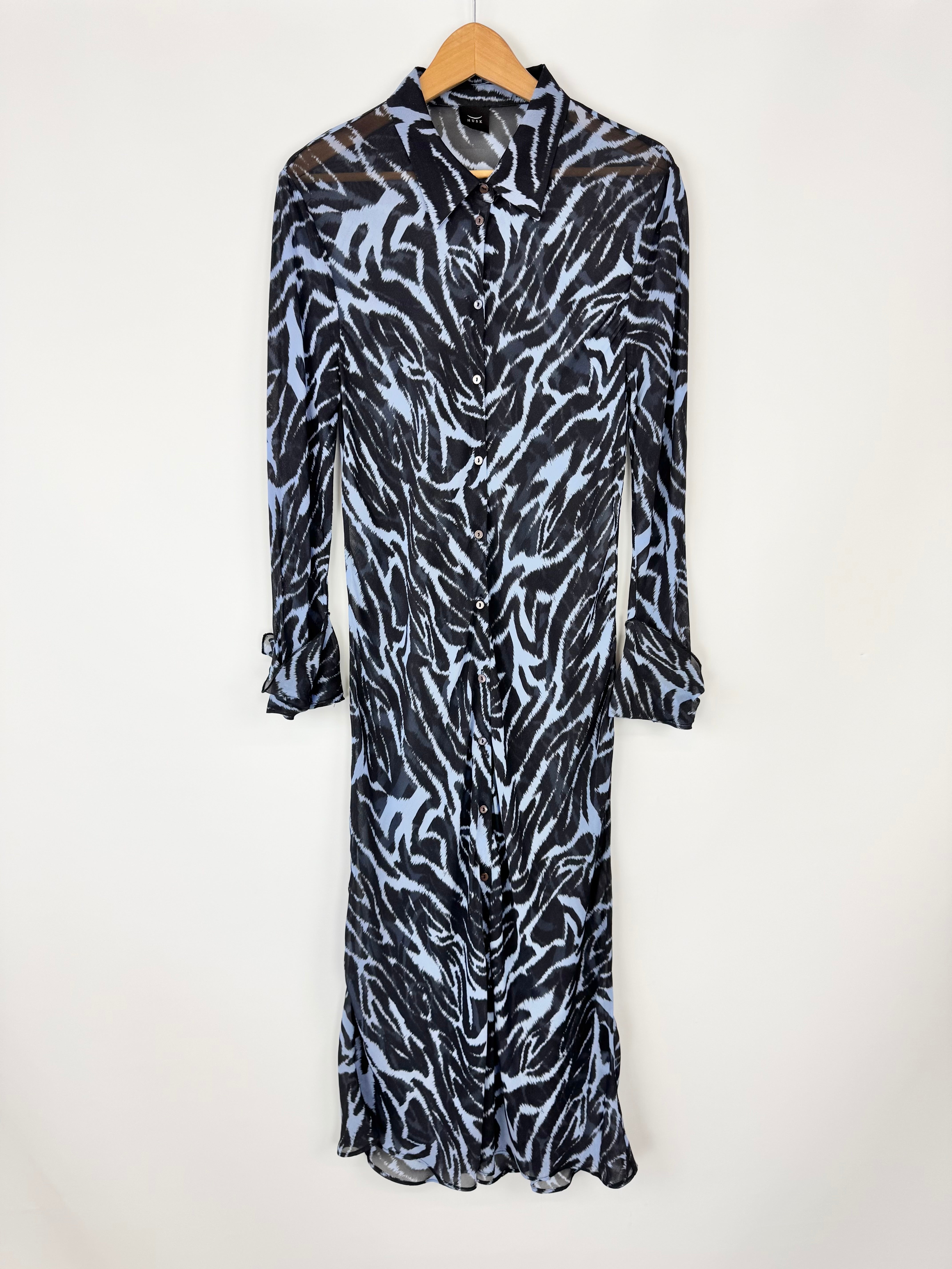 Zebra print dress on a hanger against a white background