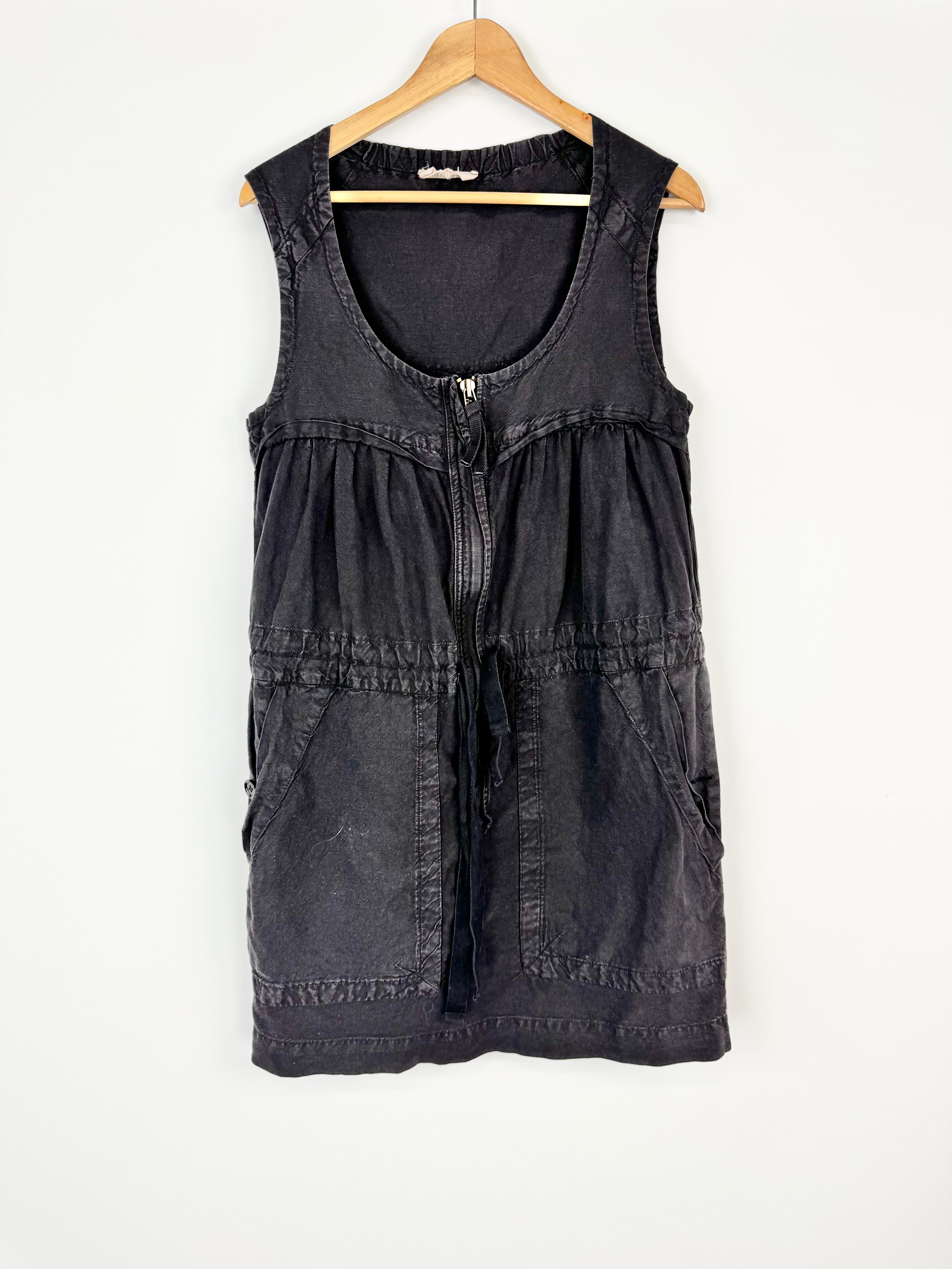 Black sleeveless dress on a wooden hanger against a white background
