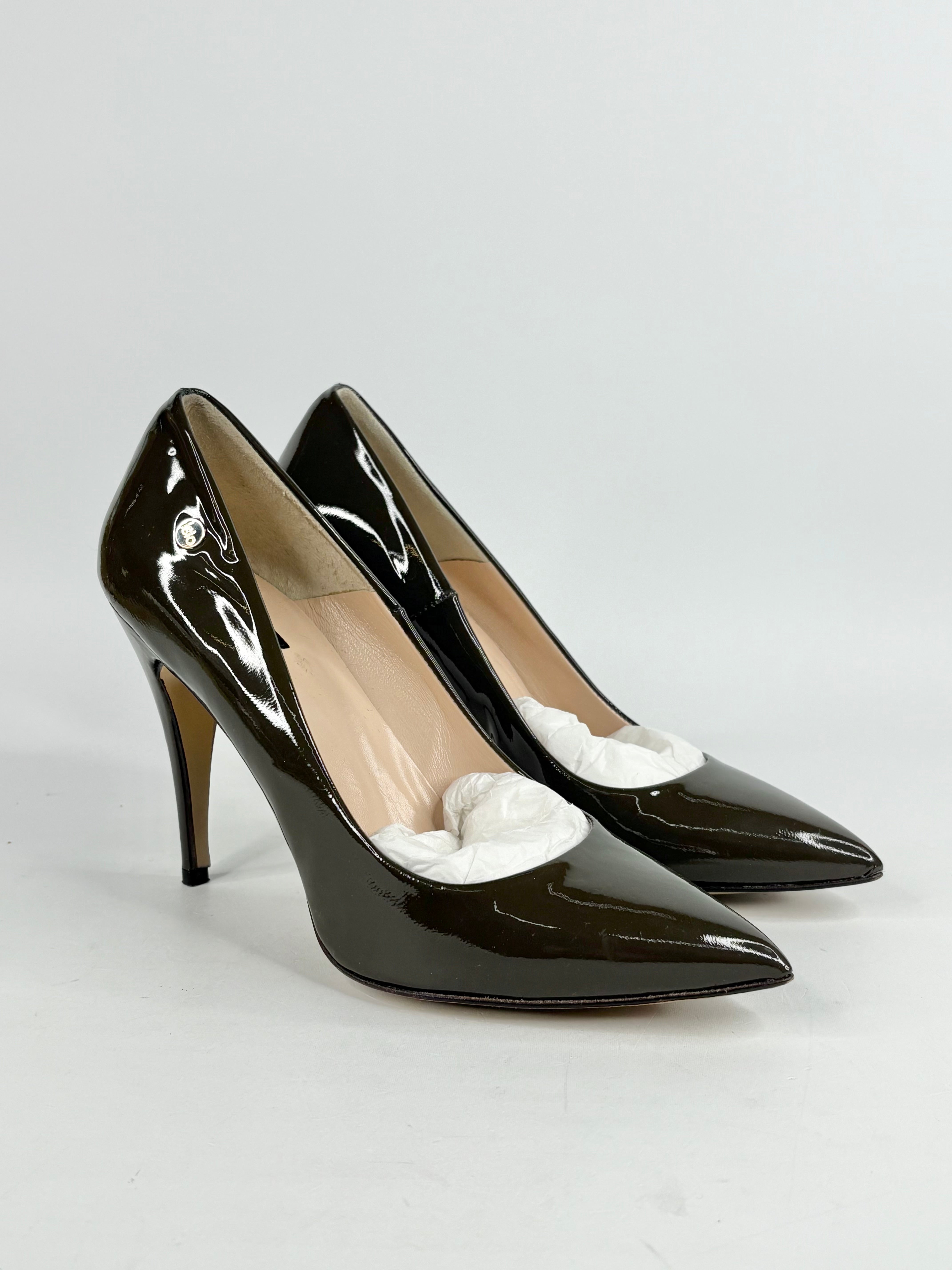 Taupe patent high-heeled shoes with white flowers on a light gray background