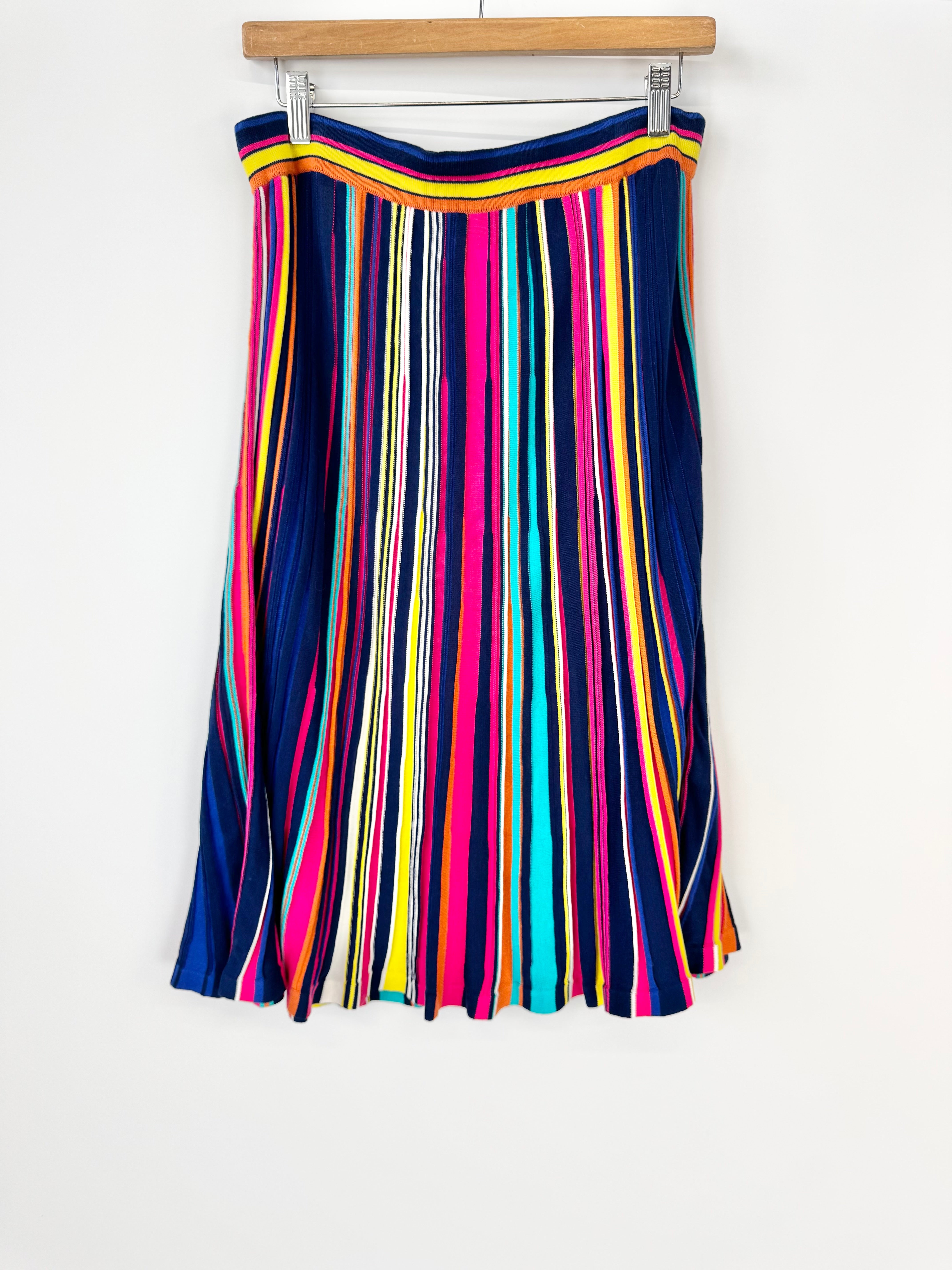 Colorful striped skirt on a hanger against a white background