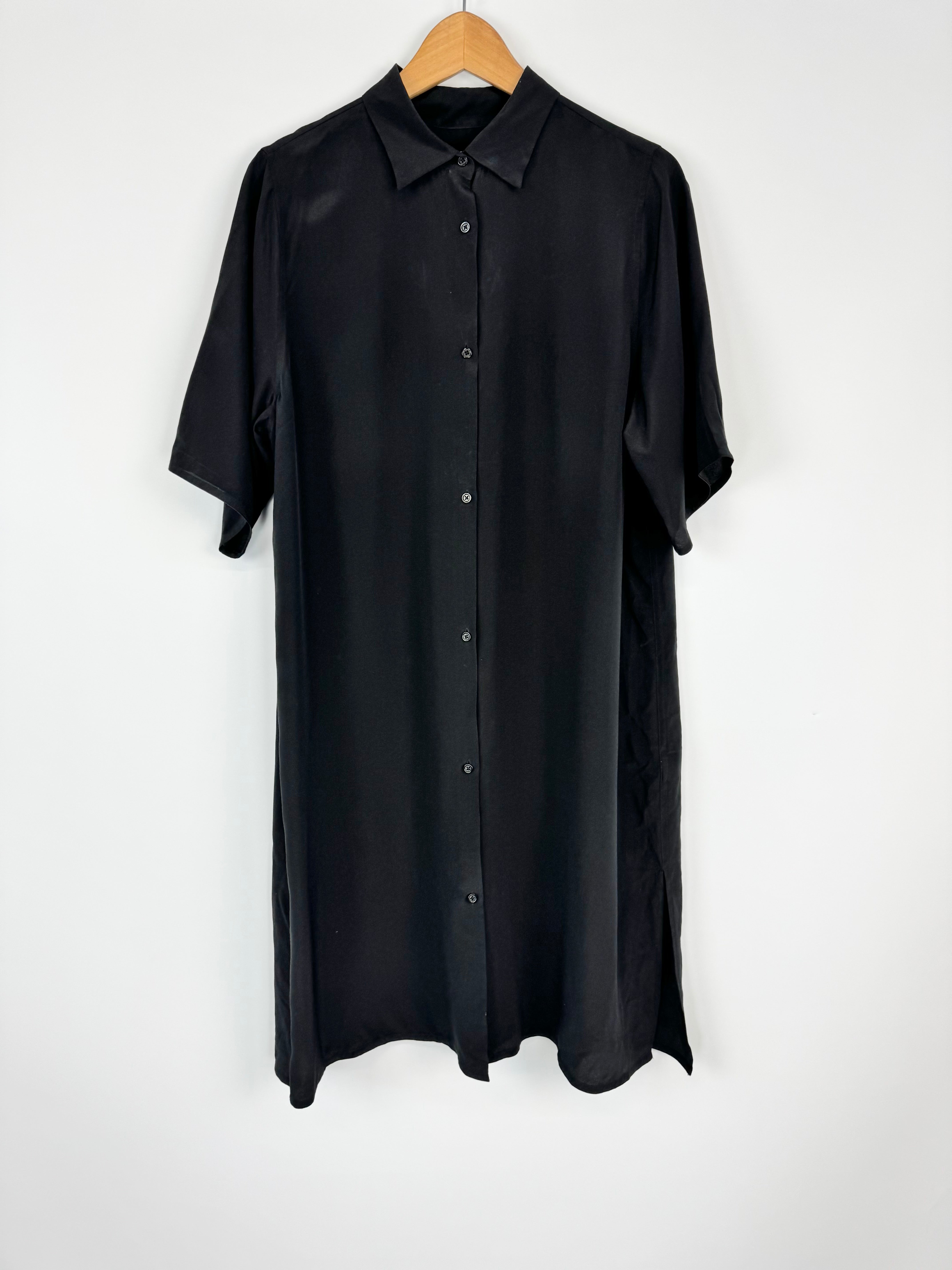 Black shirt on a hanger against a white background