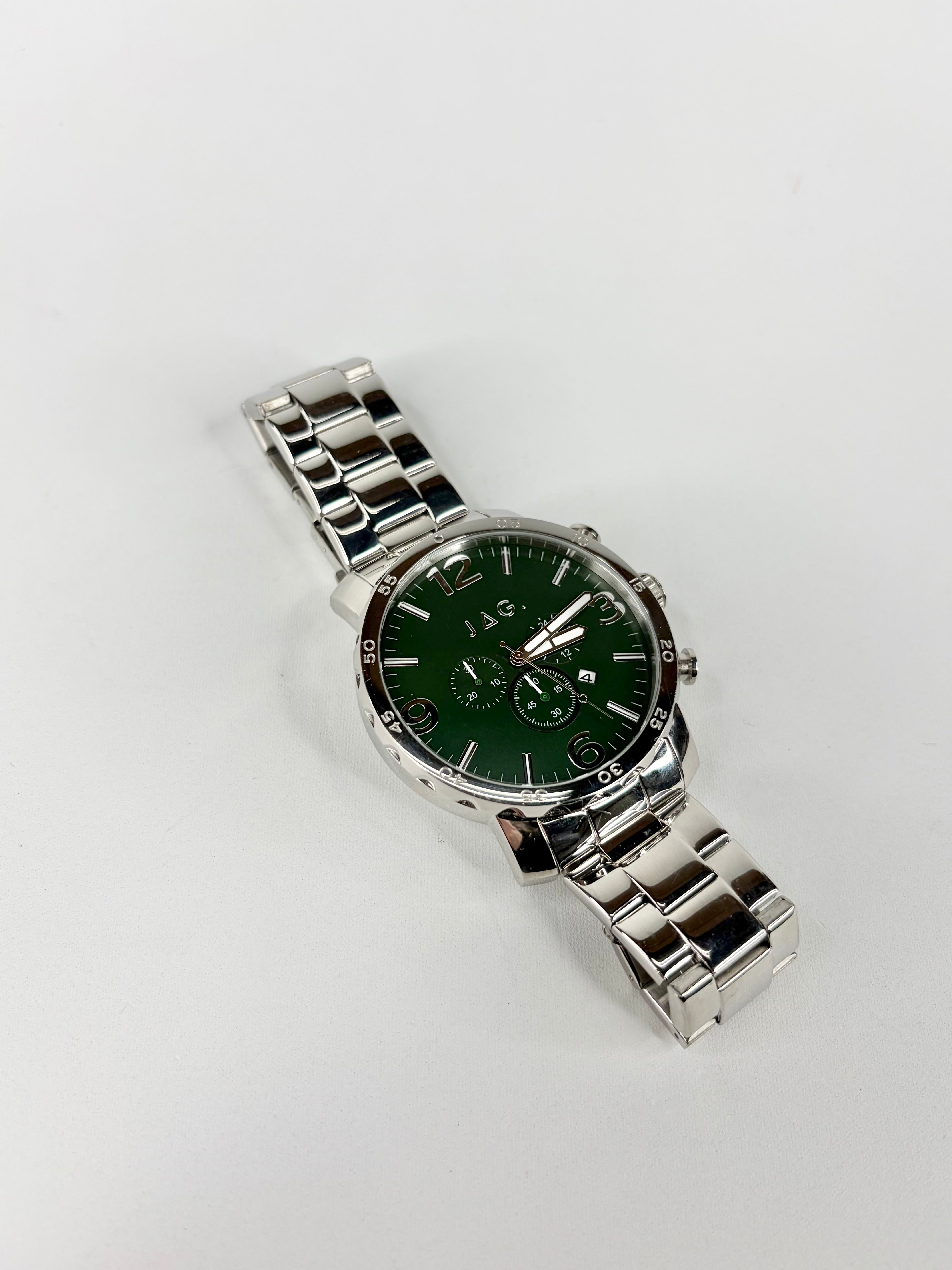 Silver watch with a green face on a white background