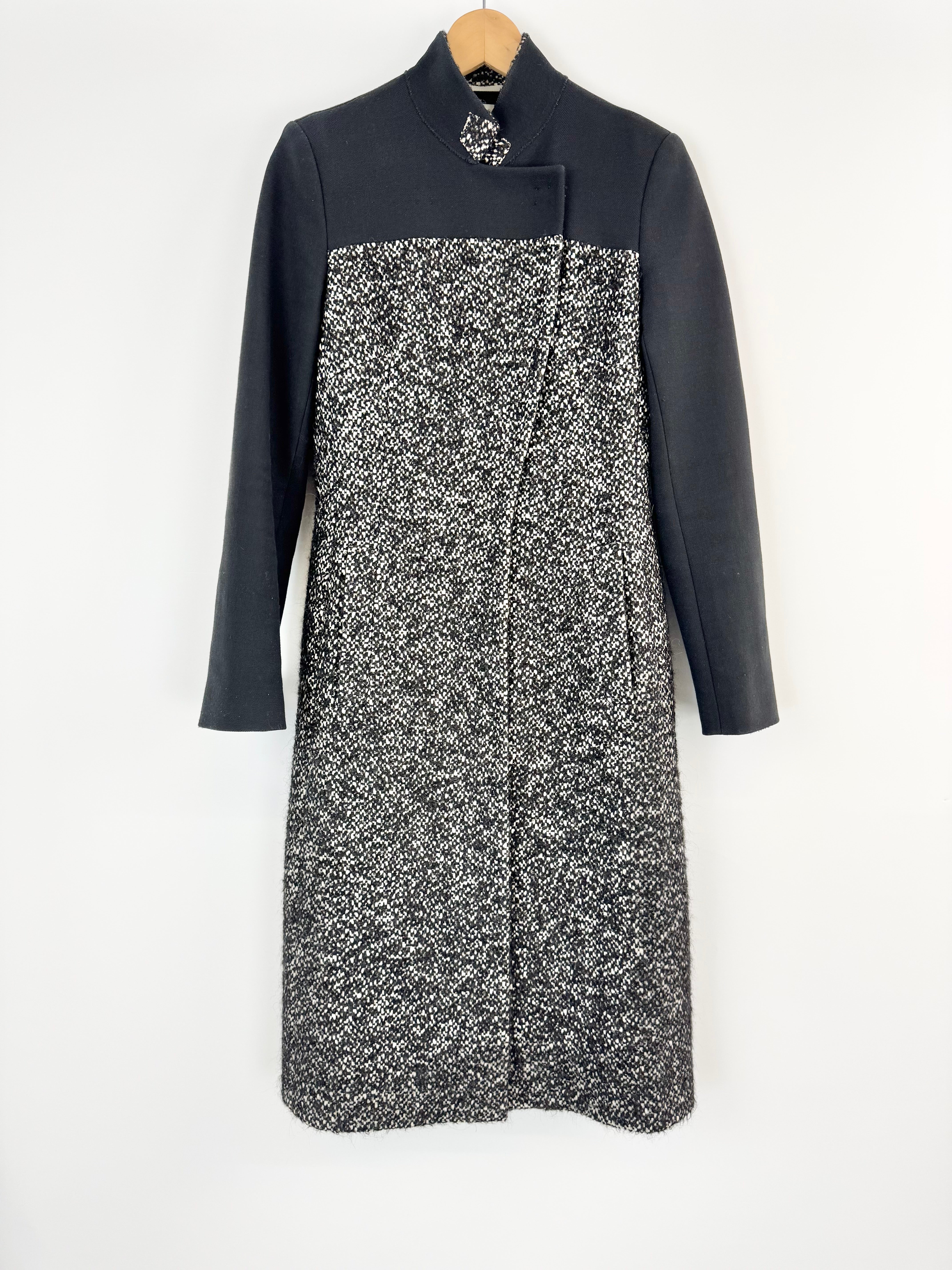 Black and white patterned dress on a hanger against a white background