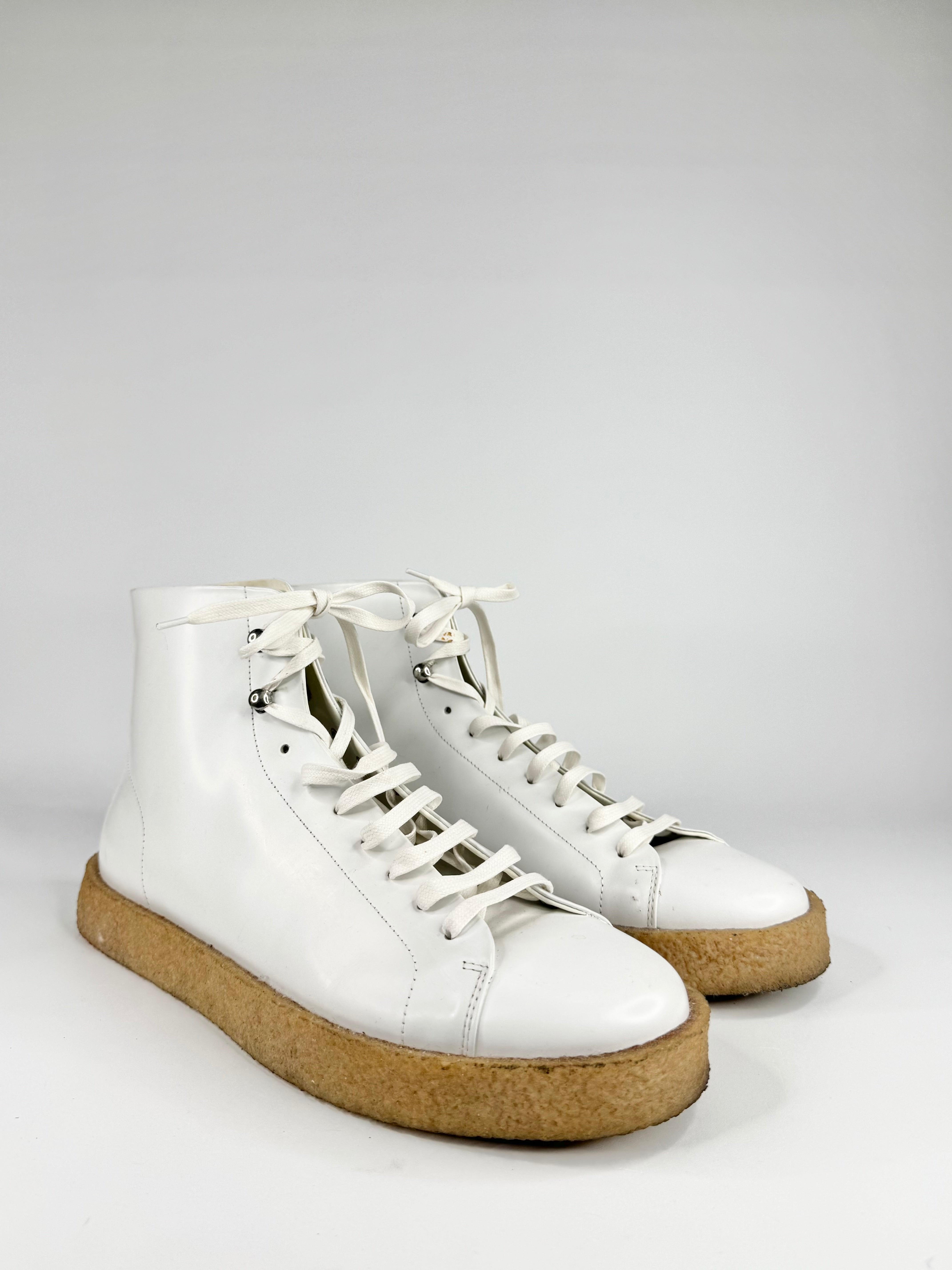 White high-top sneakers with cork soles on a light gray background