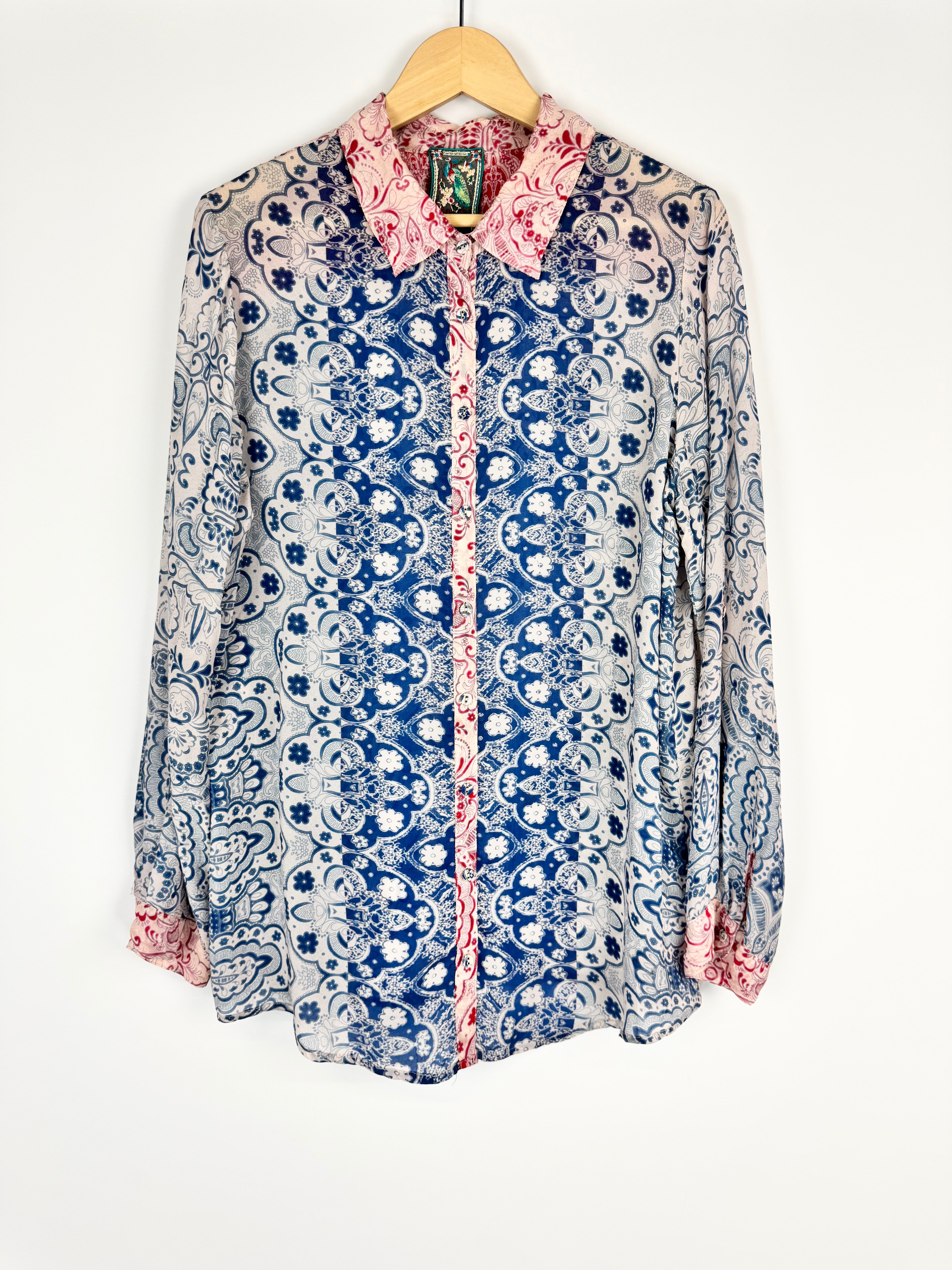 Patterned shirt on a hanger against a white background