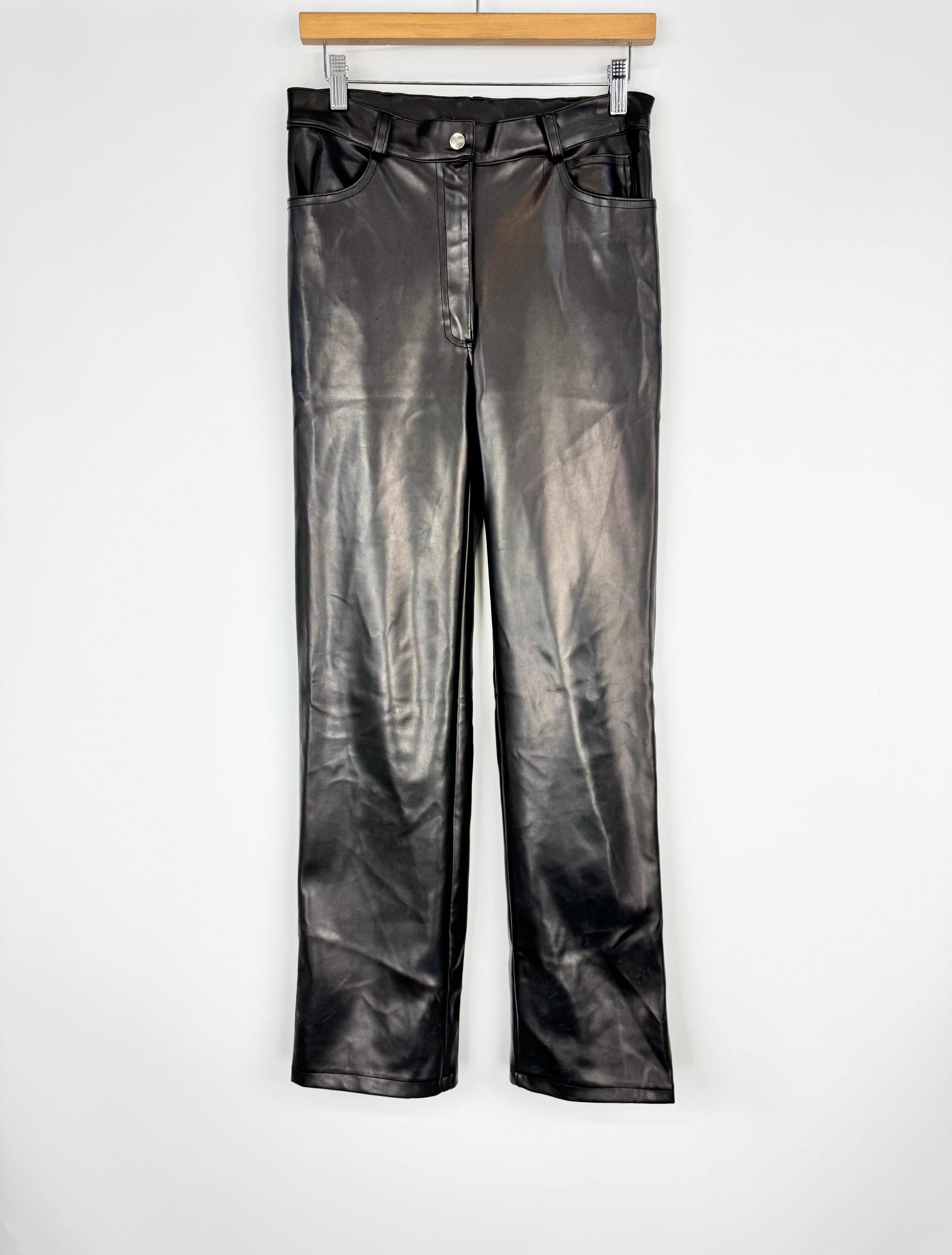 Black leather pants on a hanger against a white background
