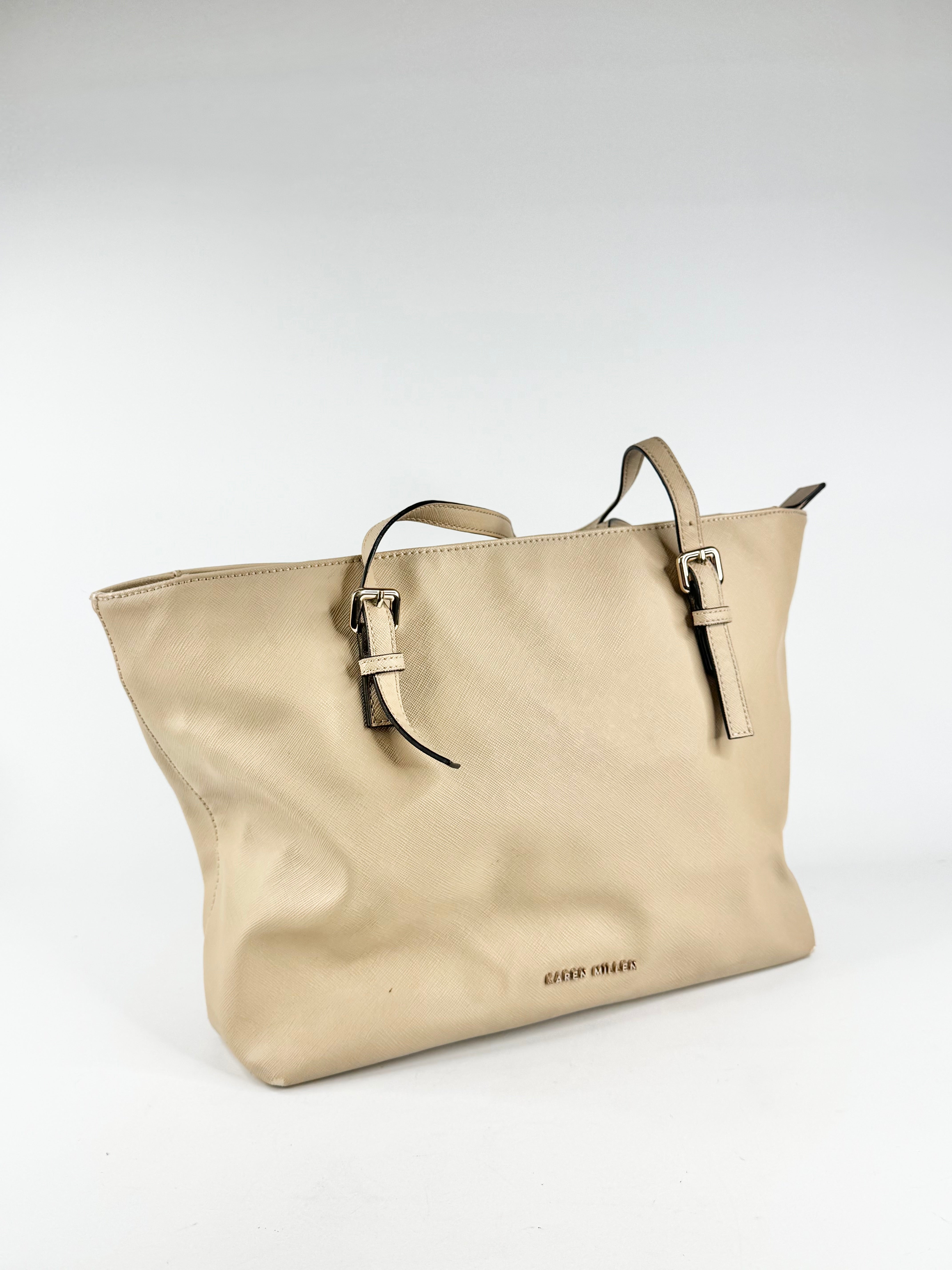 Beige handbag with a visible brand logo on a white background