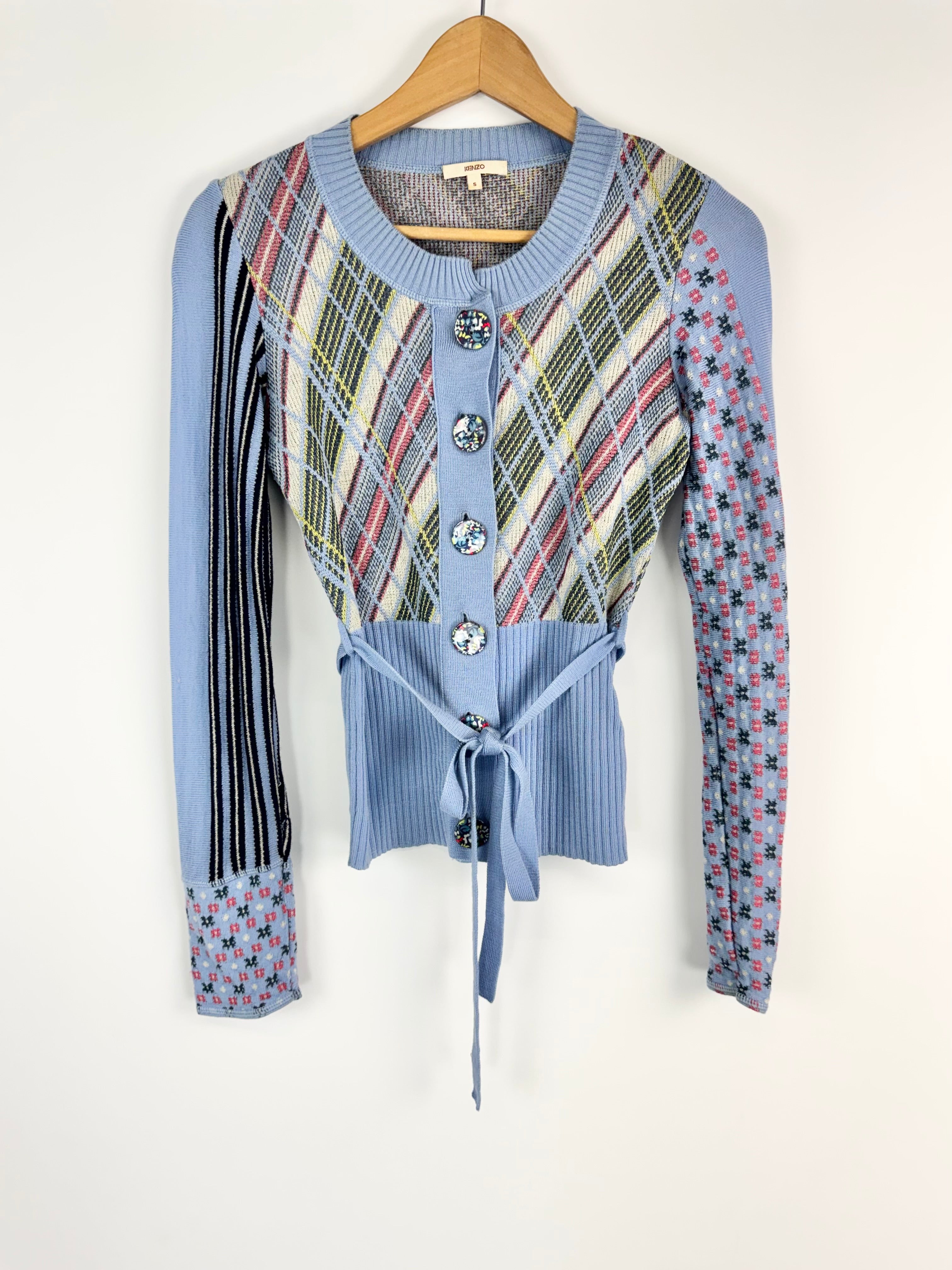 Blue cardigan with plaid pattern on a hanger against a white background