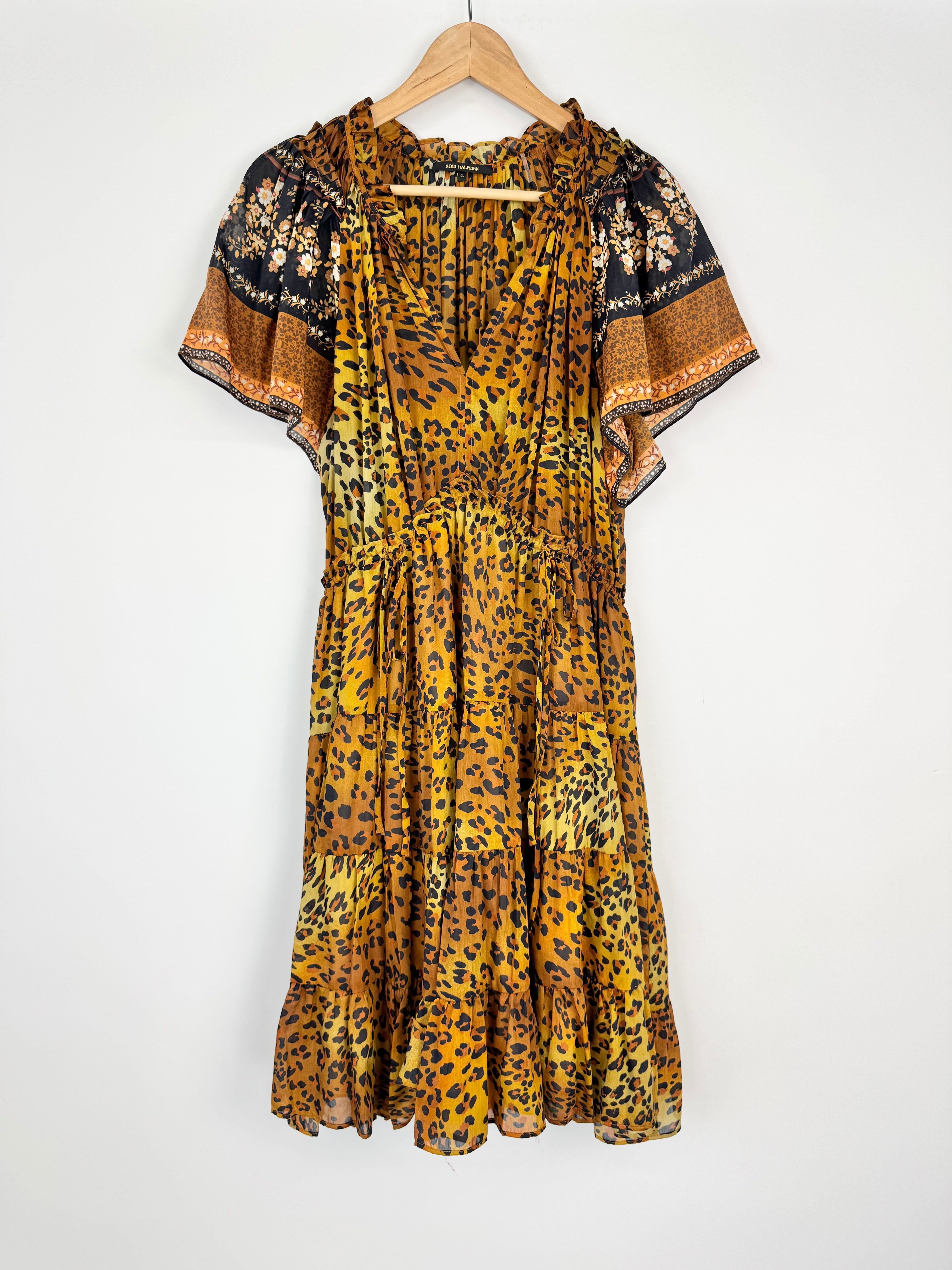 Leopard print dress on a hanger against a white background