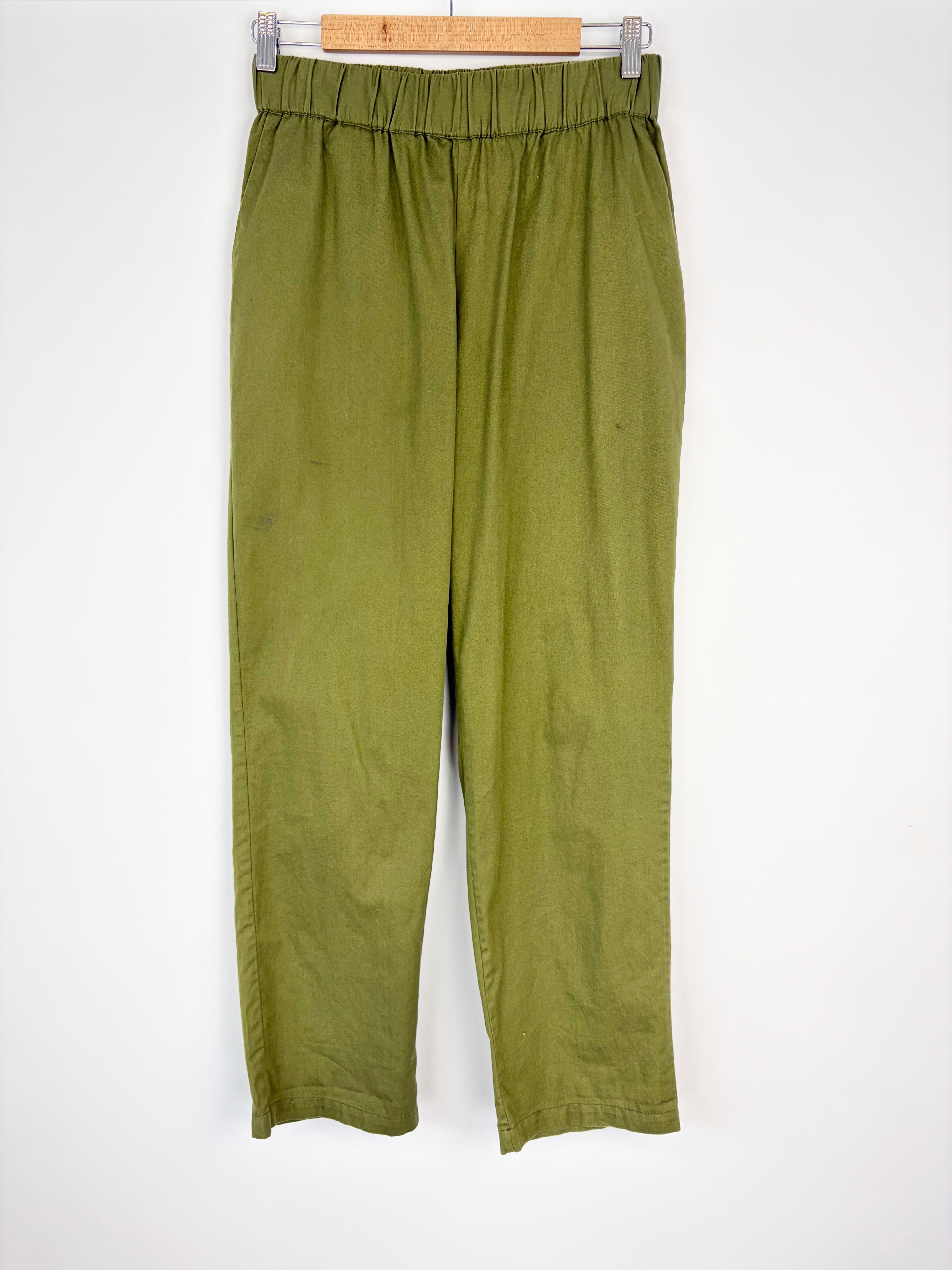 Green pants hanging on a white background