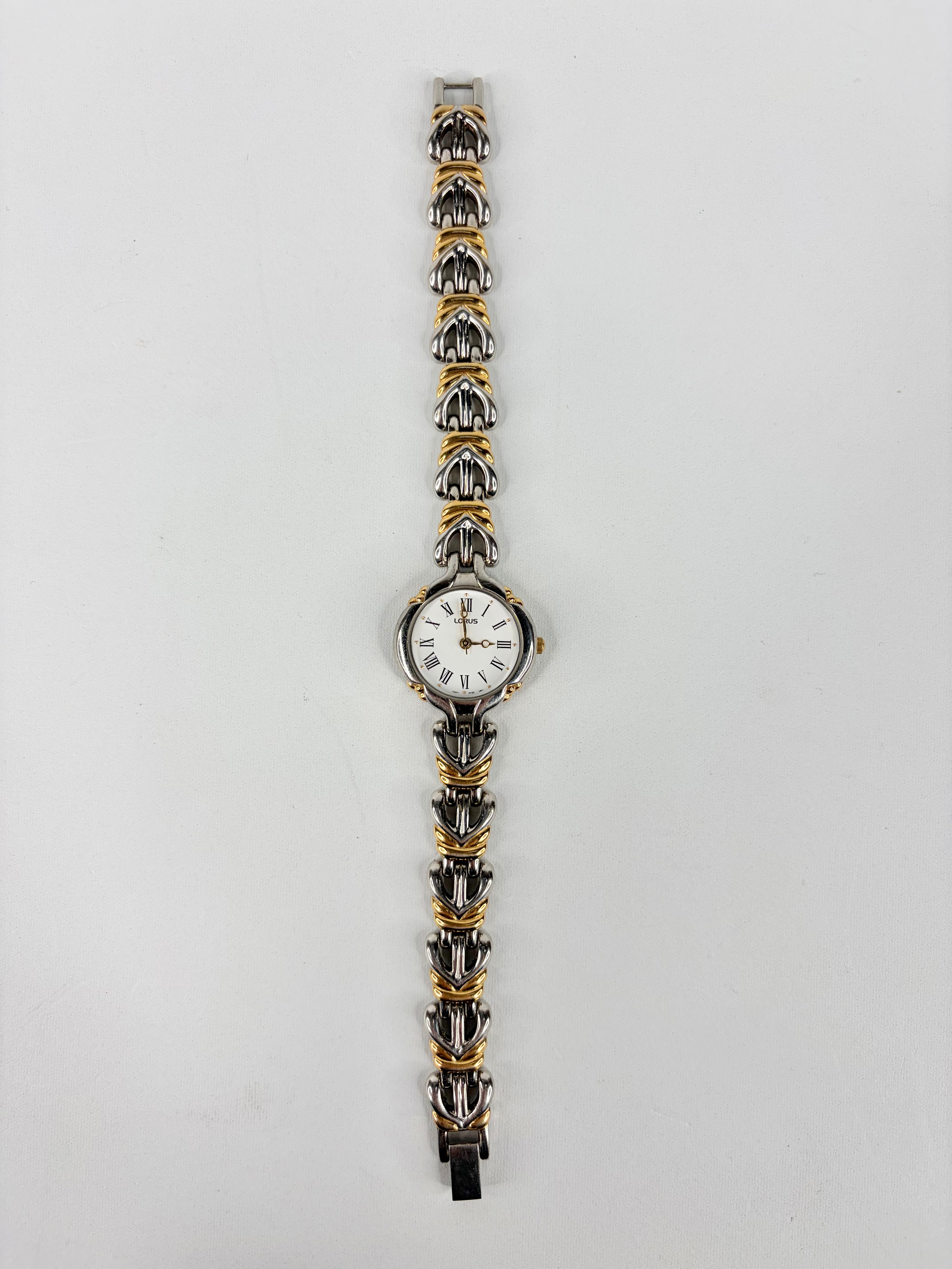 Wristwatch with a decorative metal strap on a light gray background