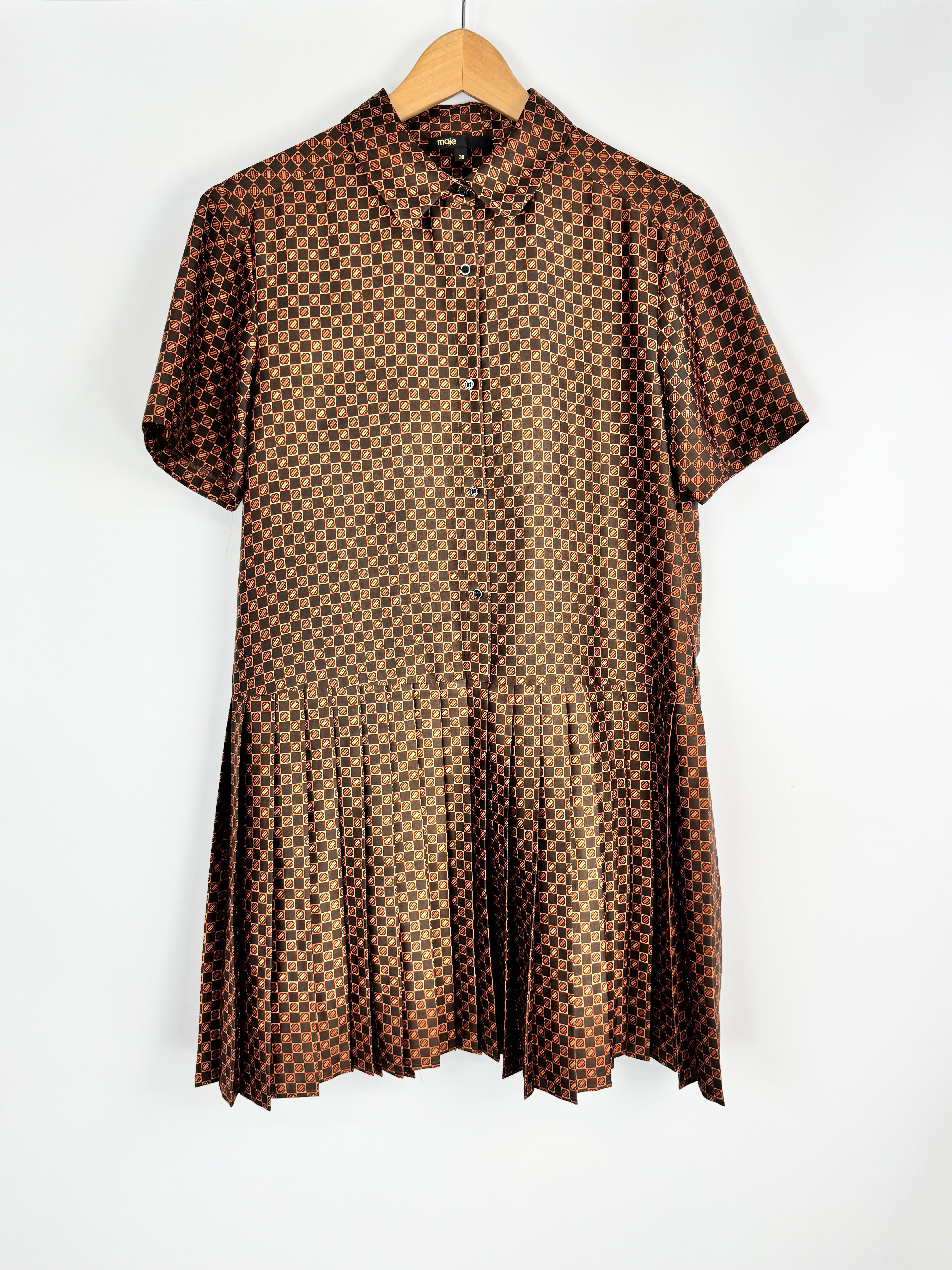 Brown patterned dress on a hanger against a white background