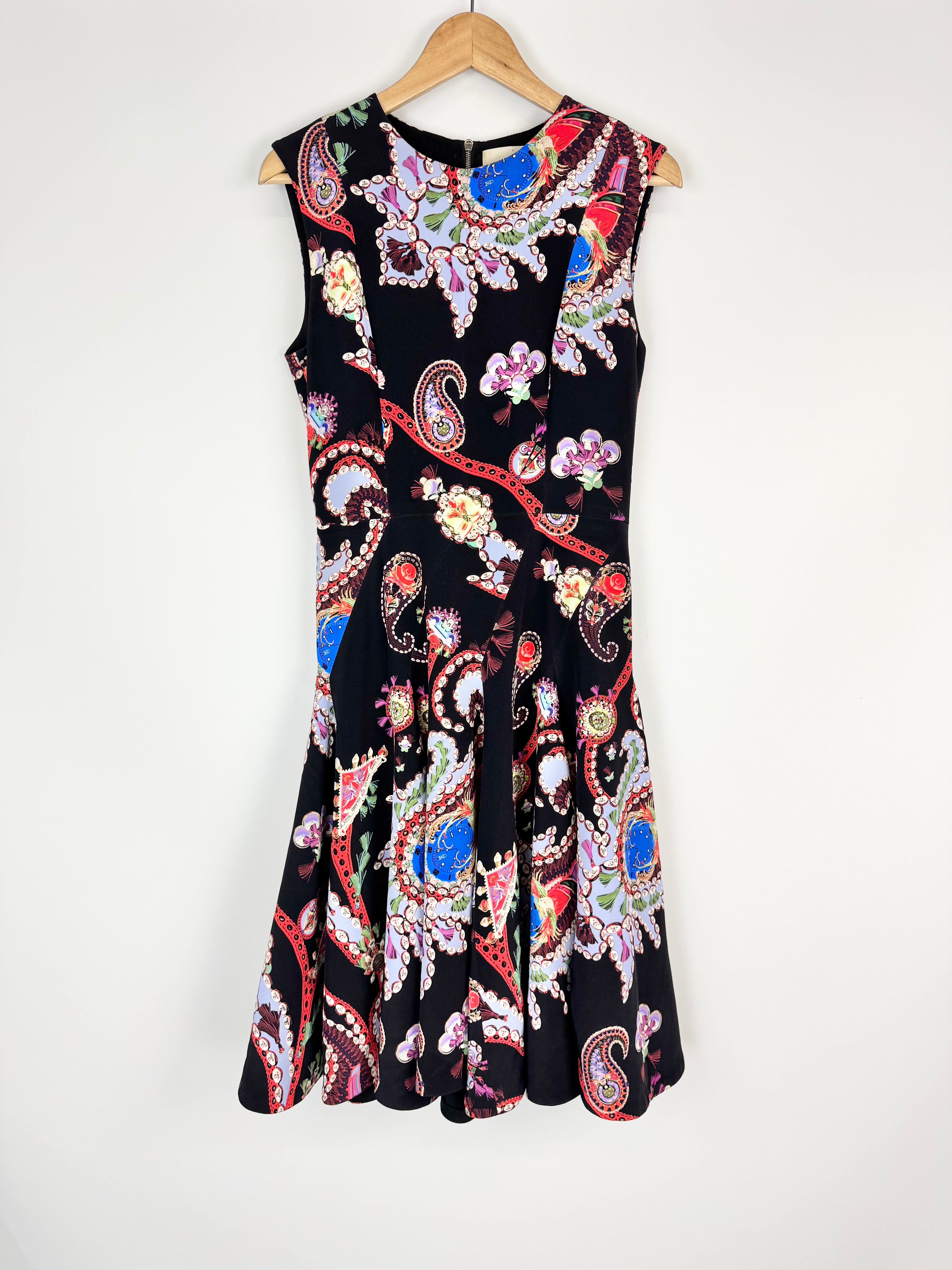 Colorful patterned dress on a hanger against a white background