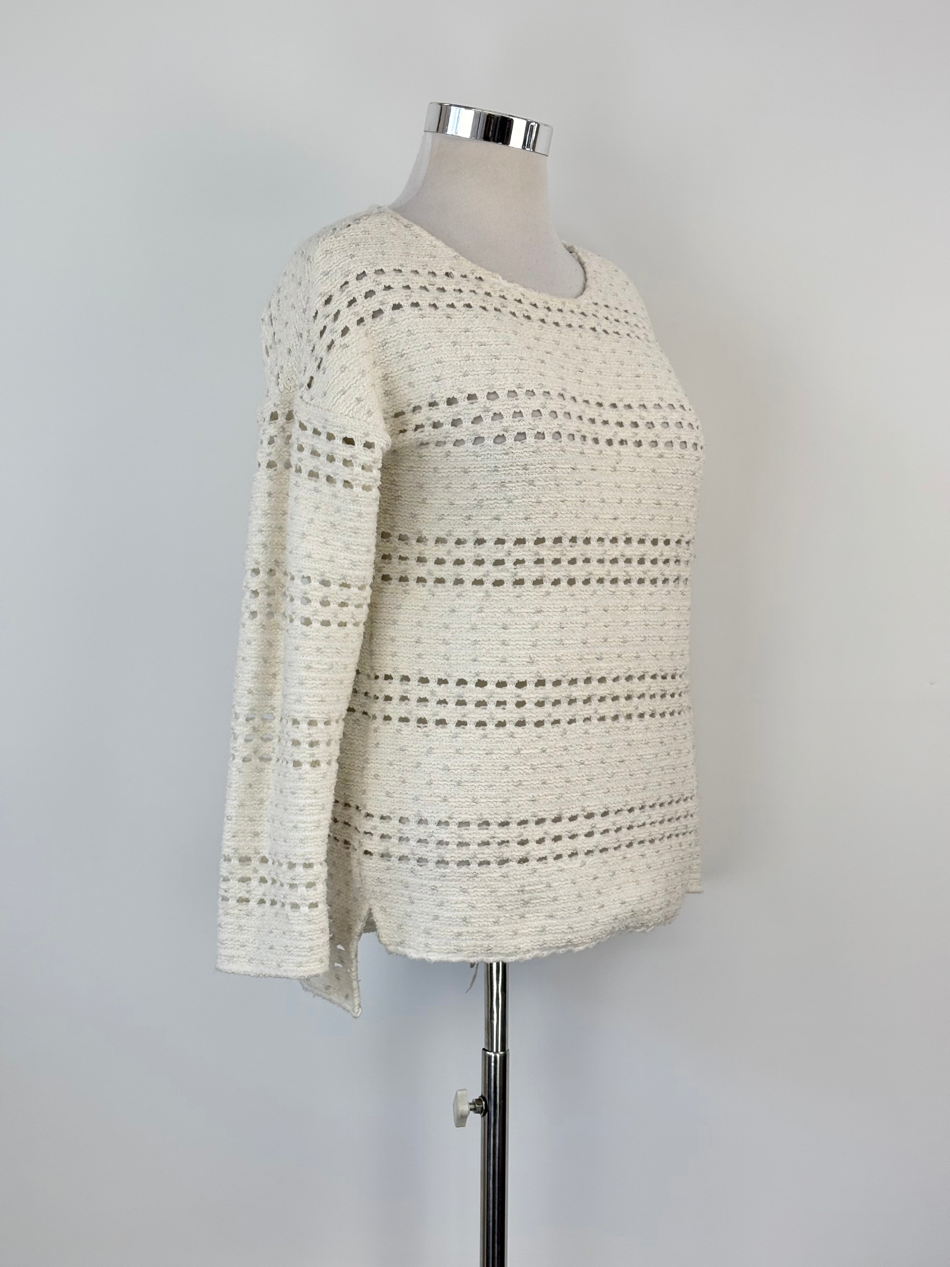 A cream and silver sparkly crochet knit sweater displayed on a mannequin against a white background.