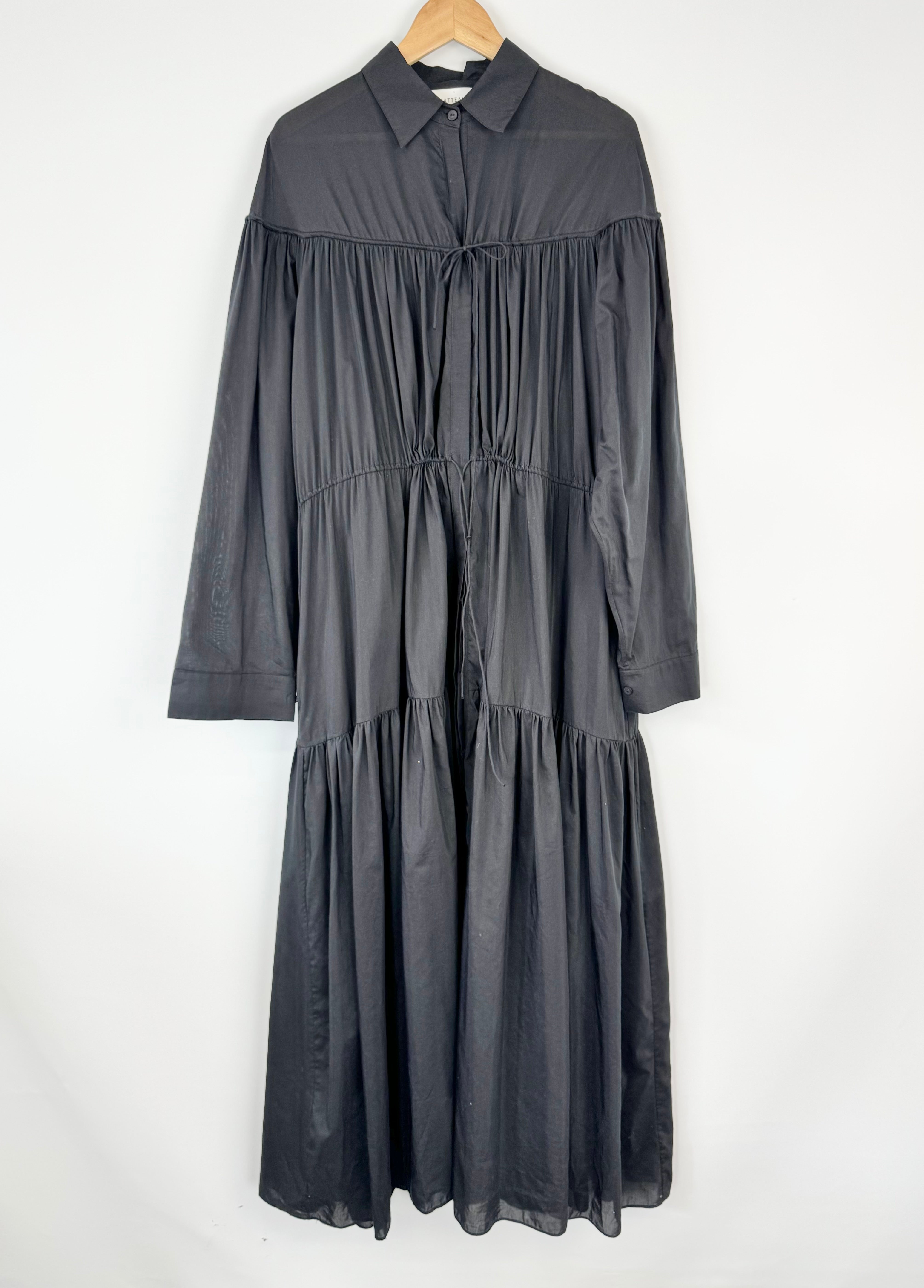 Dark gray dress on a hanger against a white background