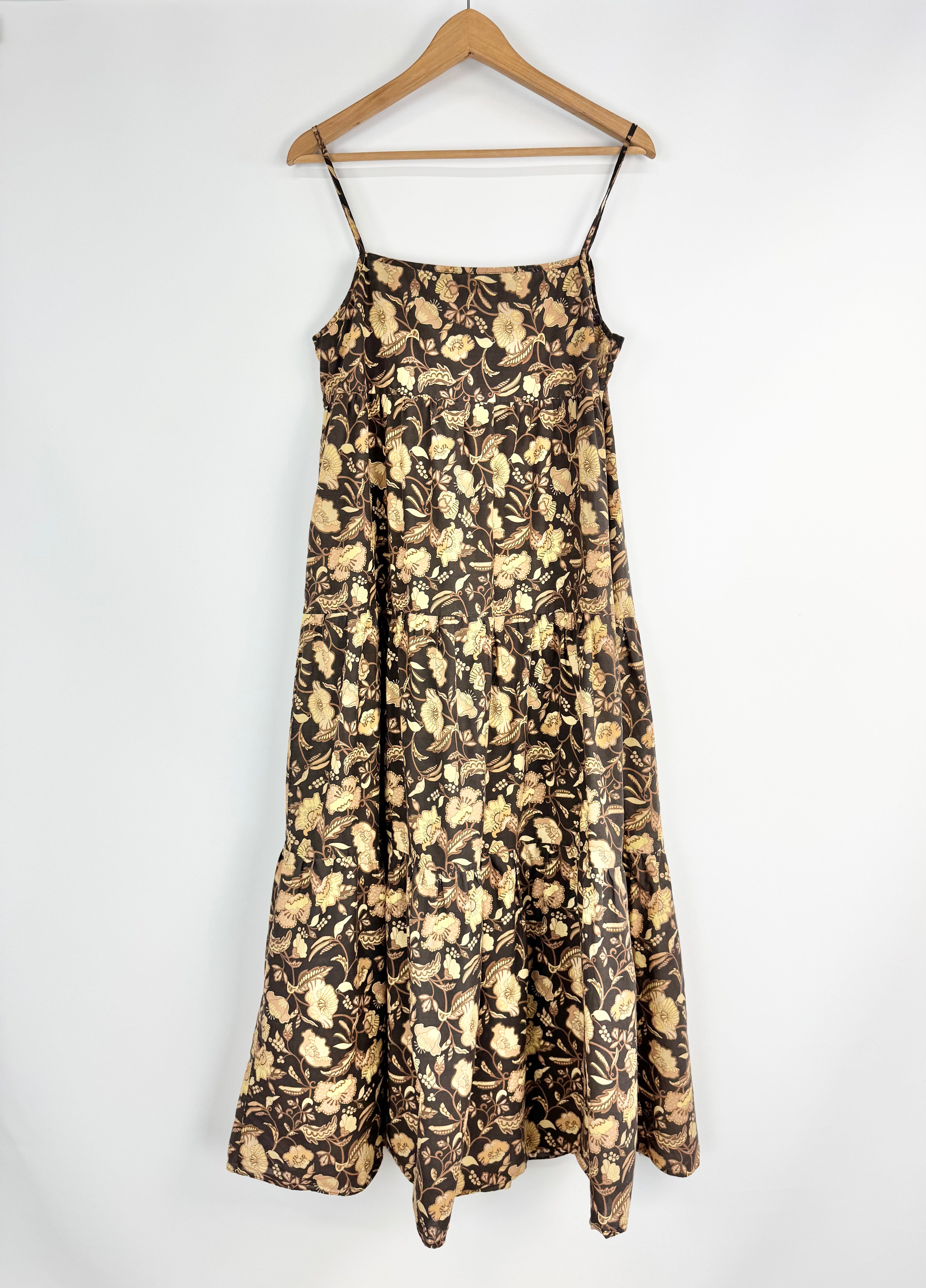 Floral patterned dress on a hanger against a white background