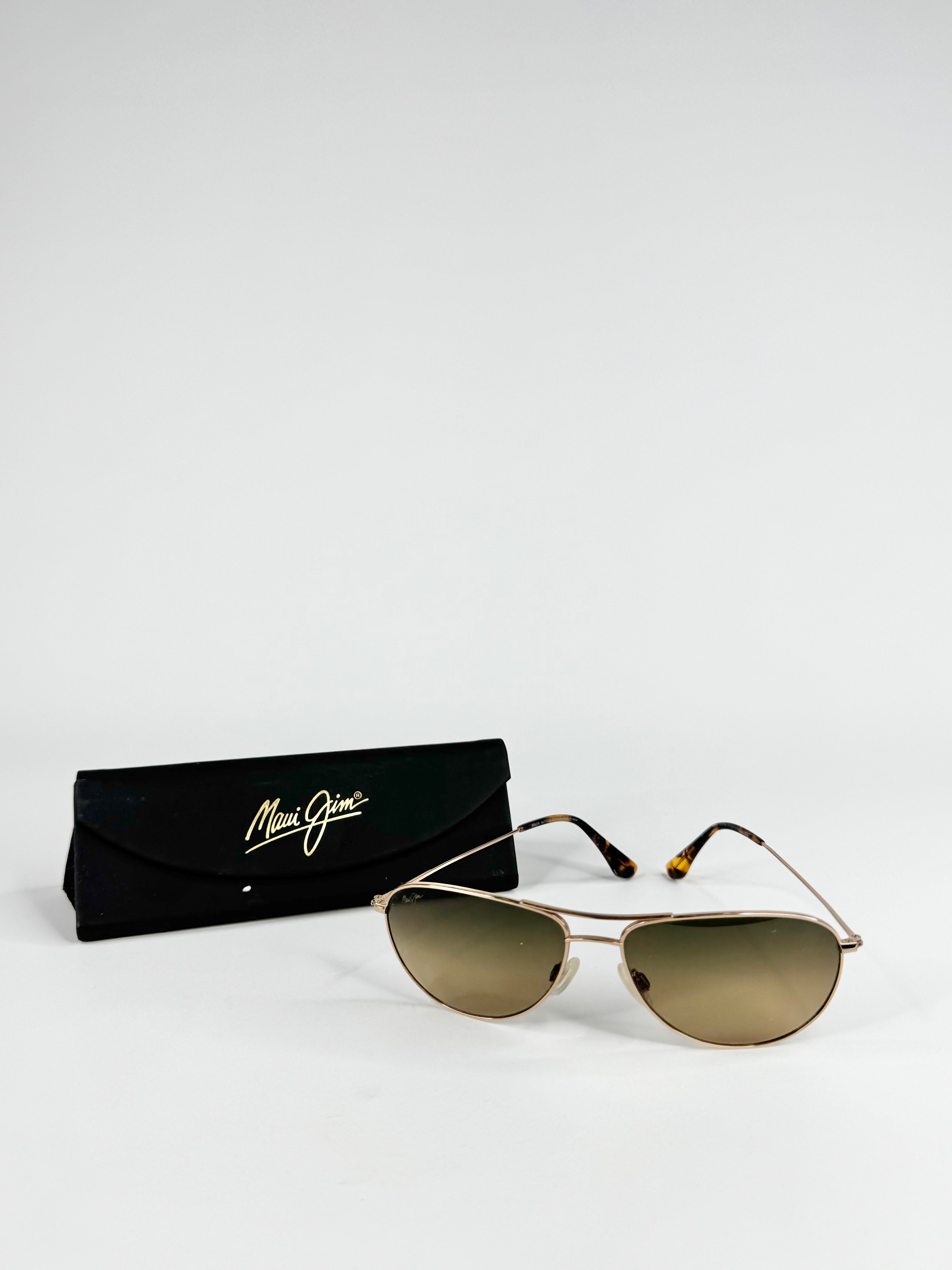 Aviator sunglasses with gold gradient lenses and a black case on a white background