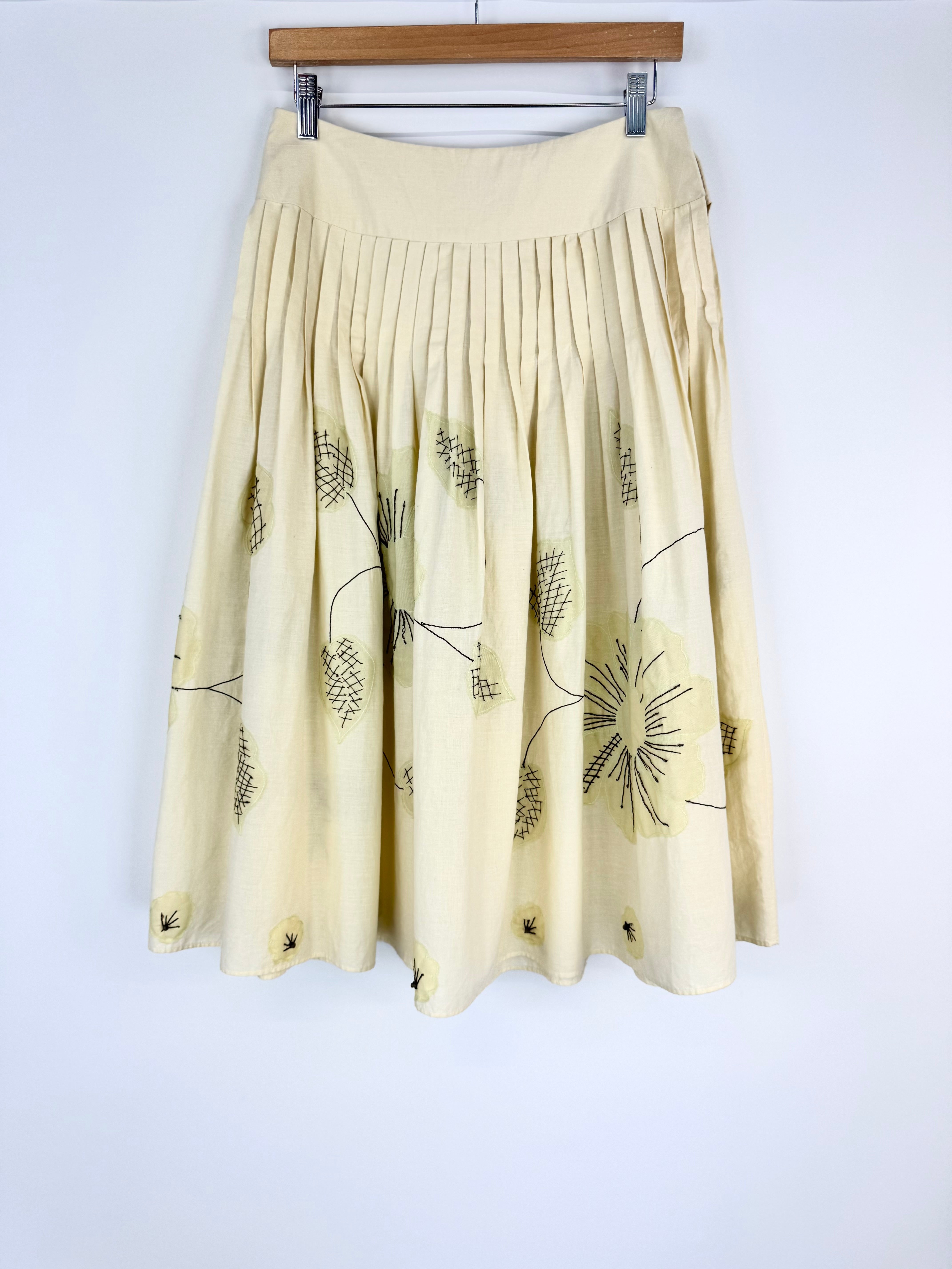 Beige skirt with black floral patterns on a white background