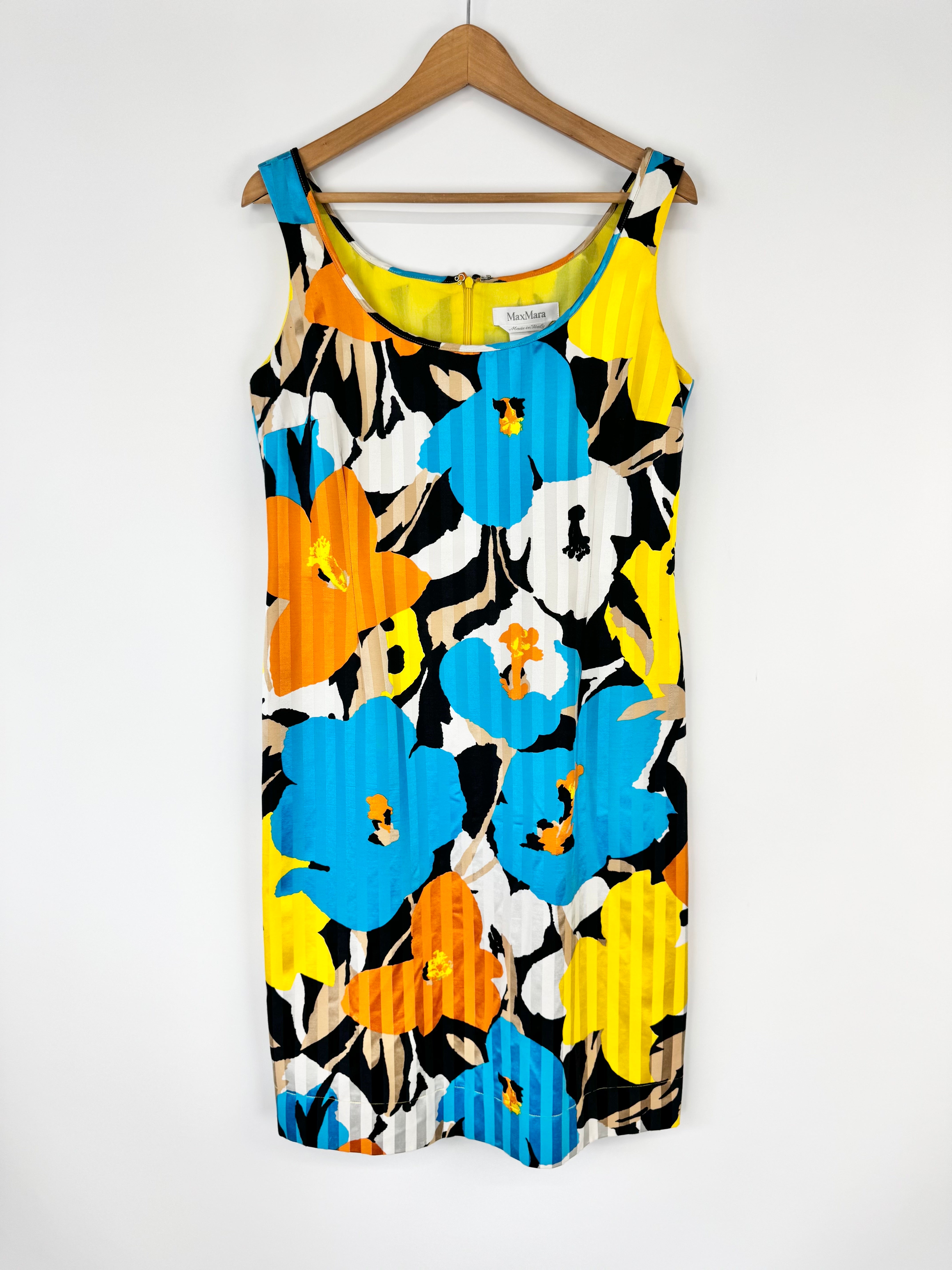Colorful floral dress on a hanger against a white background